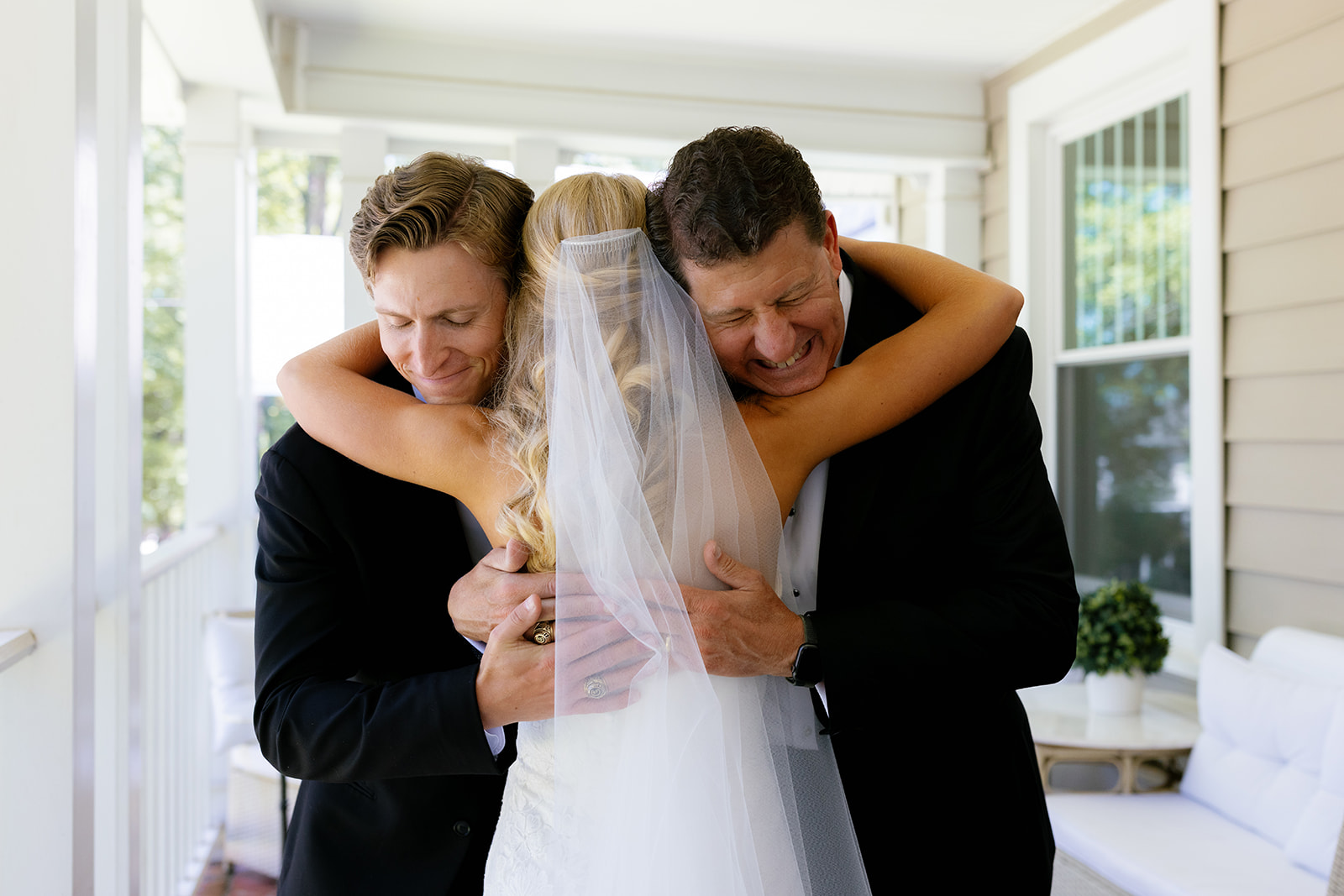 Bride shares a heartfelt embrace with her father and brother during an emotional first look moment. This is such a special addition to any Wedding Weekend Timeline.