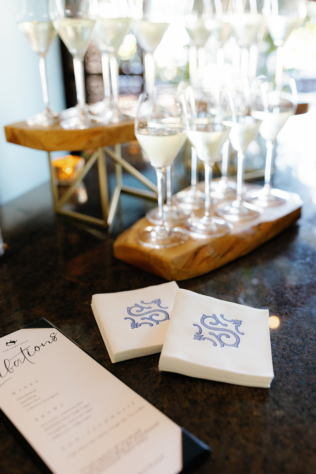 Elegant wedding bar setup with champagne glasses, monogrammed napkins, and a signature cocktail menu.