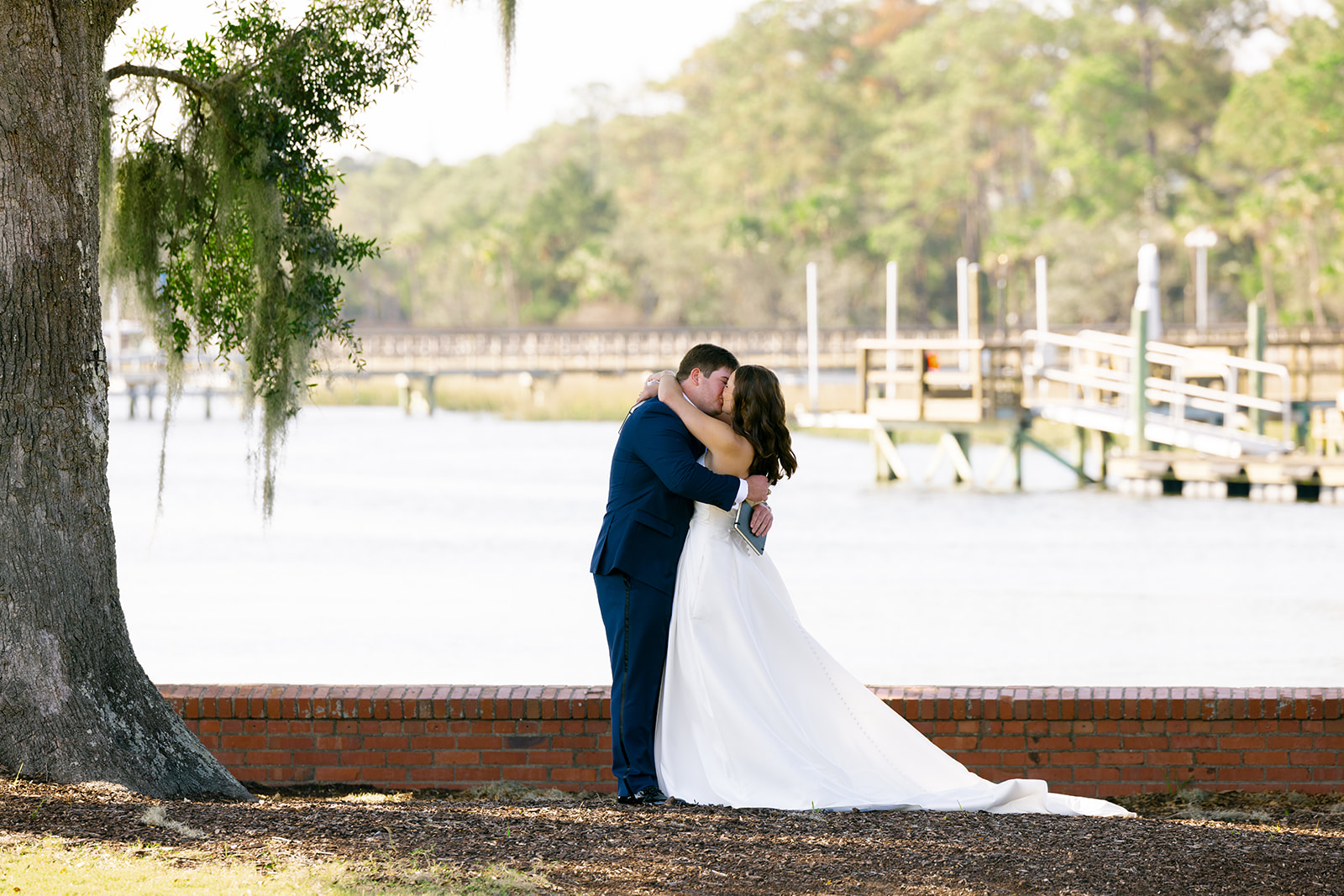Mills and Brooks share a kiss by the river during their romantic outdoor wedding in Charleston.