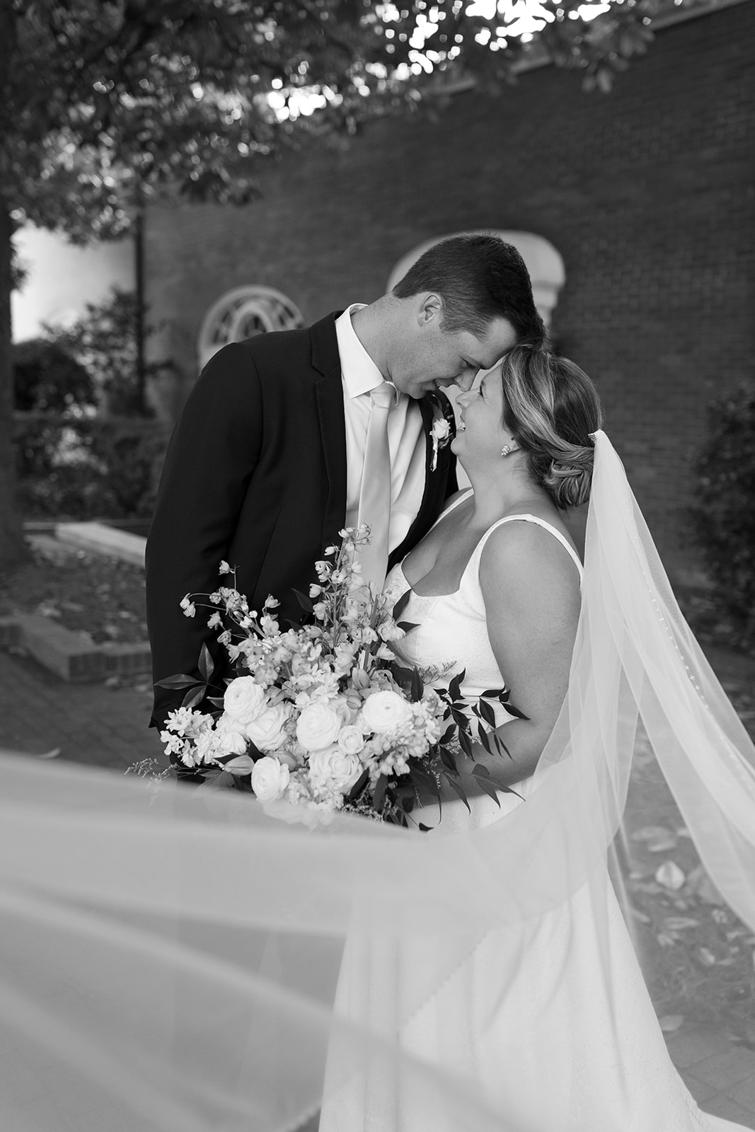bride and groom leaning into eachother and smiling taken by a Greenville wedding photographer