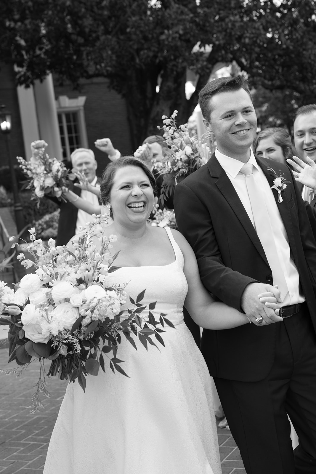 documentary wedding photo of the bridal party celebrating outside 