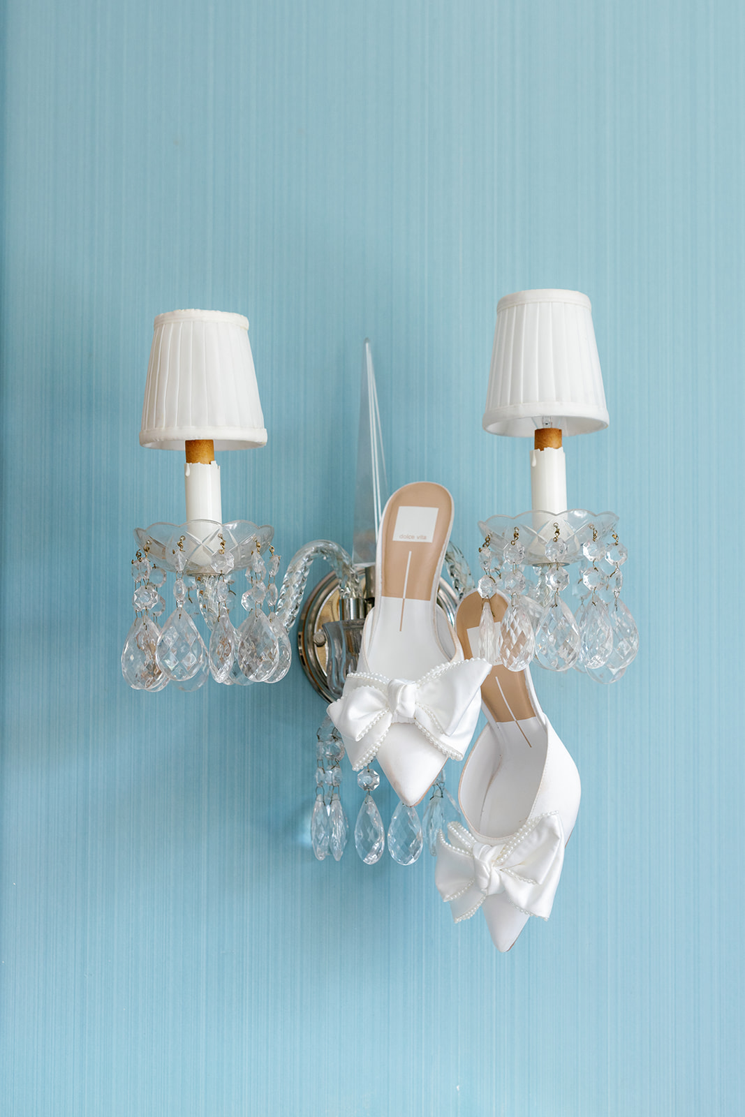 bride's wedding shoes hanging on a crystal lamp 