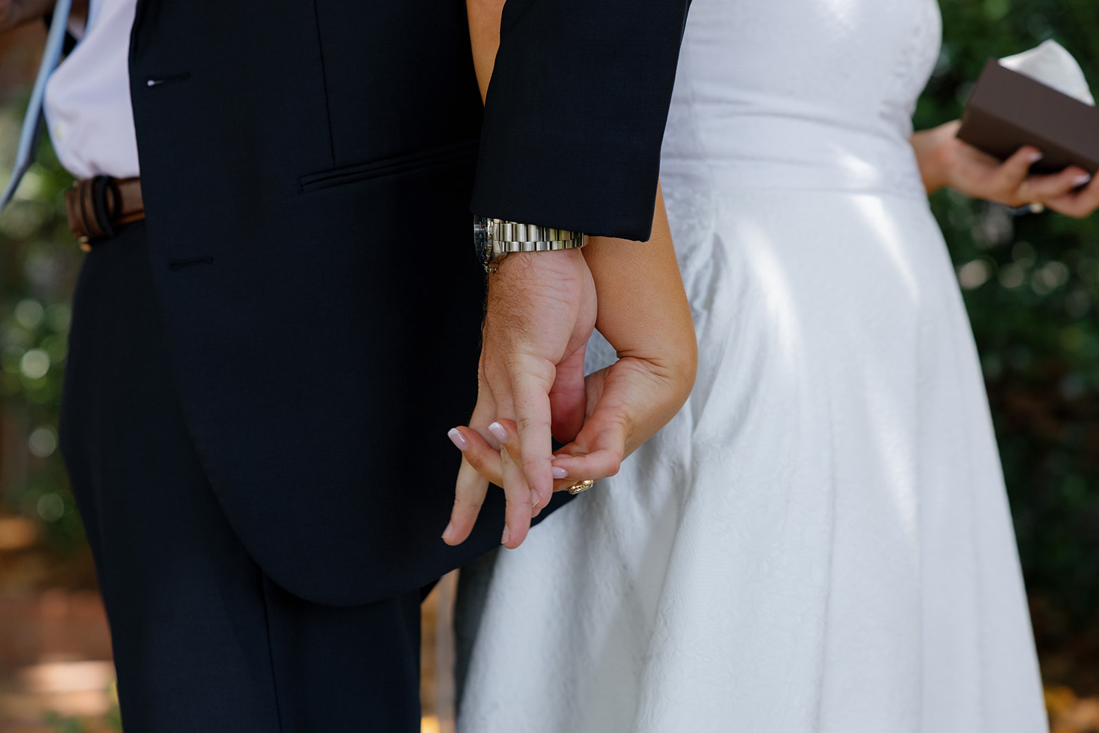 Close-up of the couple’s intertwined fingers during their emotional first touch before the ceremony.
