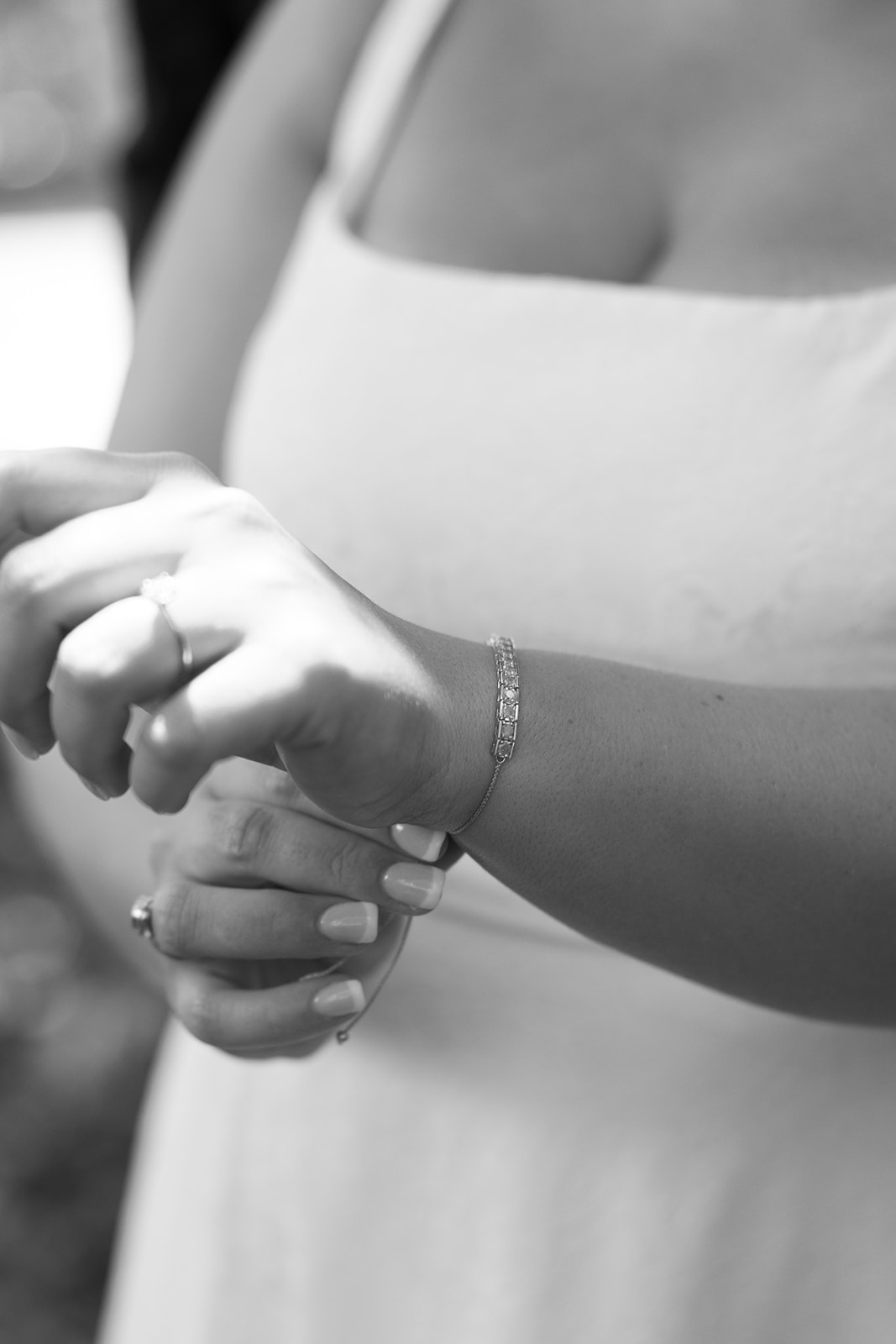 Delicate close-up of the bride fastening a sparkling bracelet over her wrist before the ceremony.