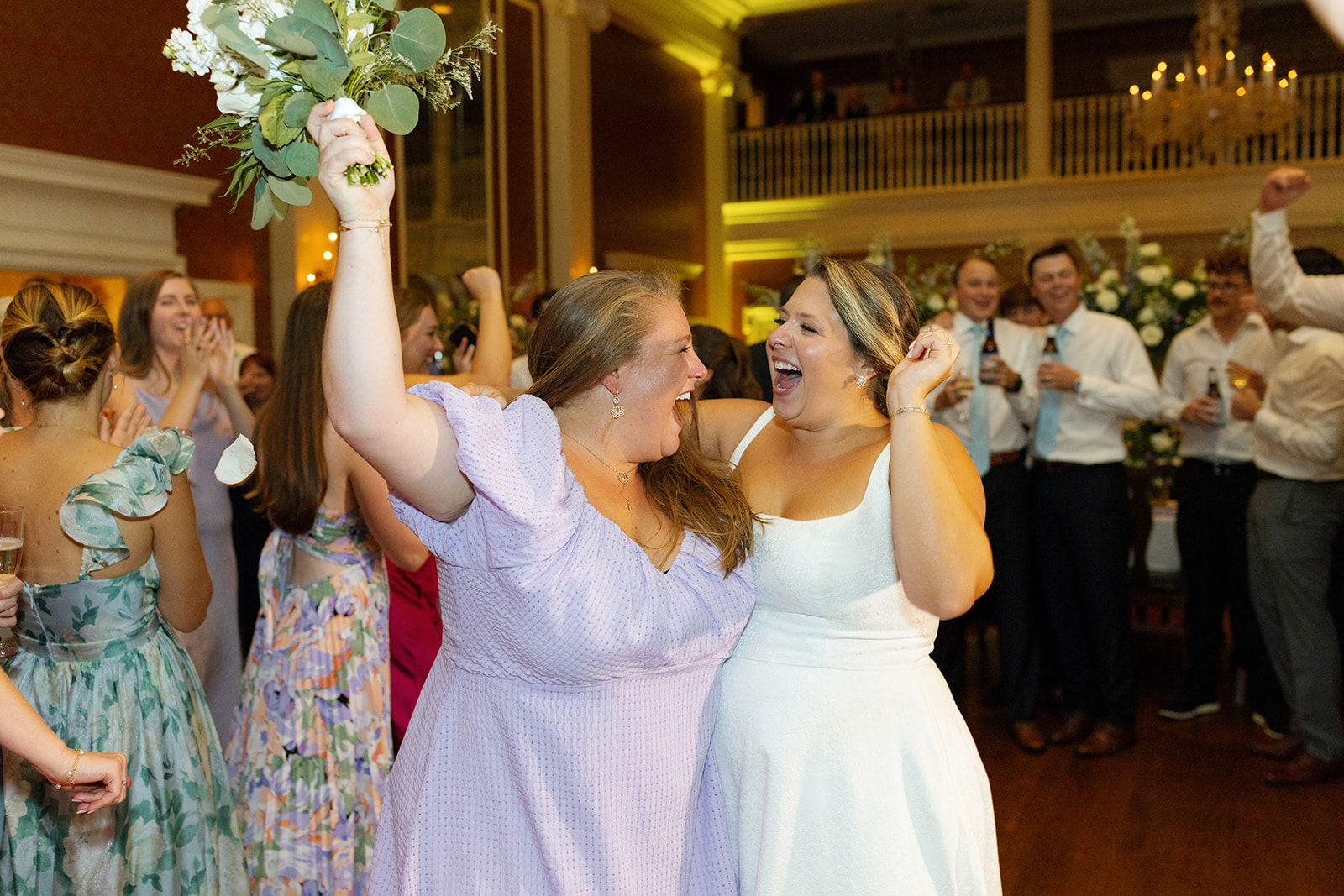 Bride shares a joyful celebration with guest who caught the bouquet