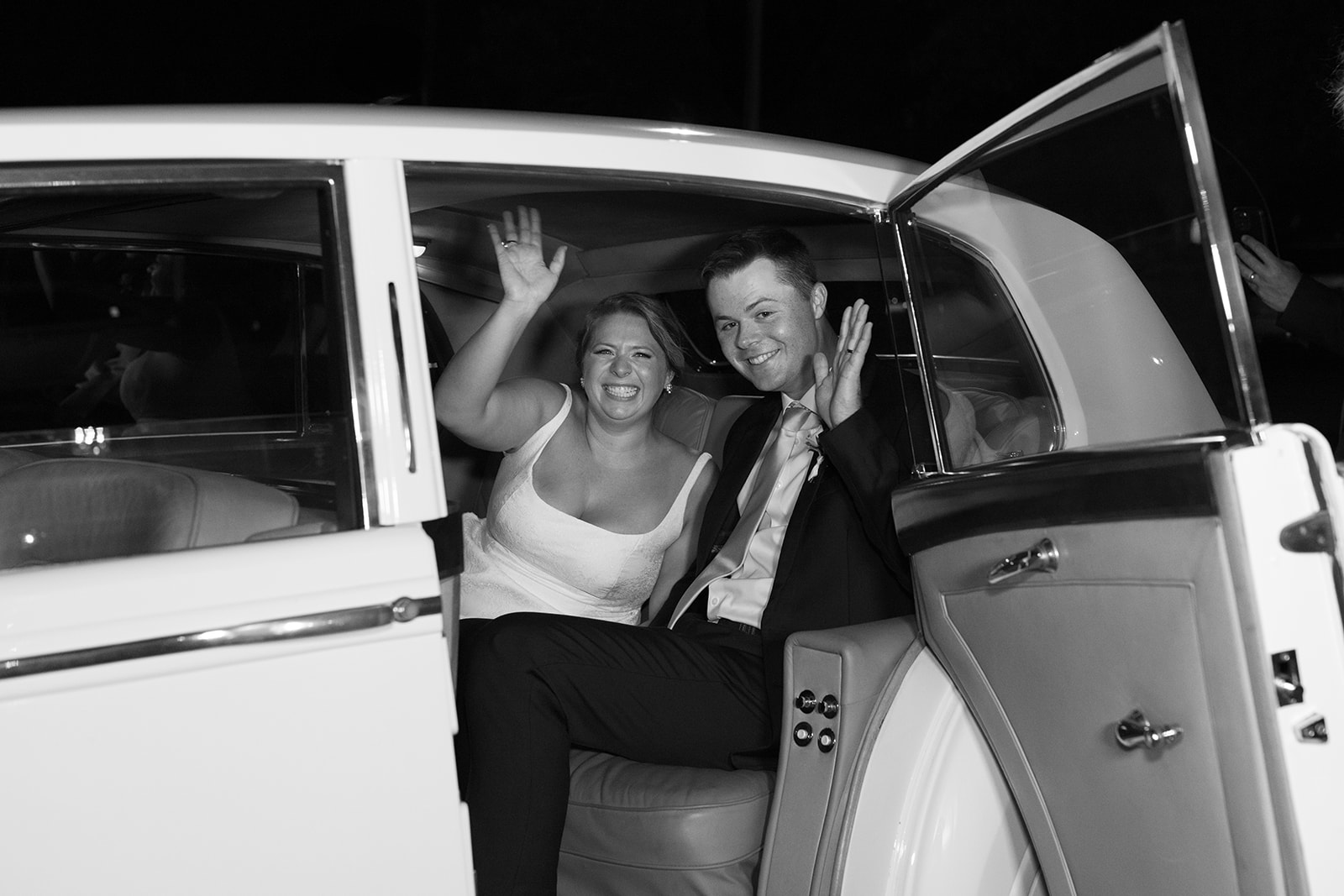 the couple waving from their getaway car