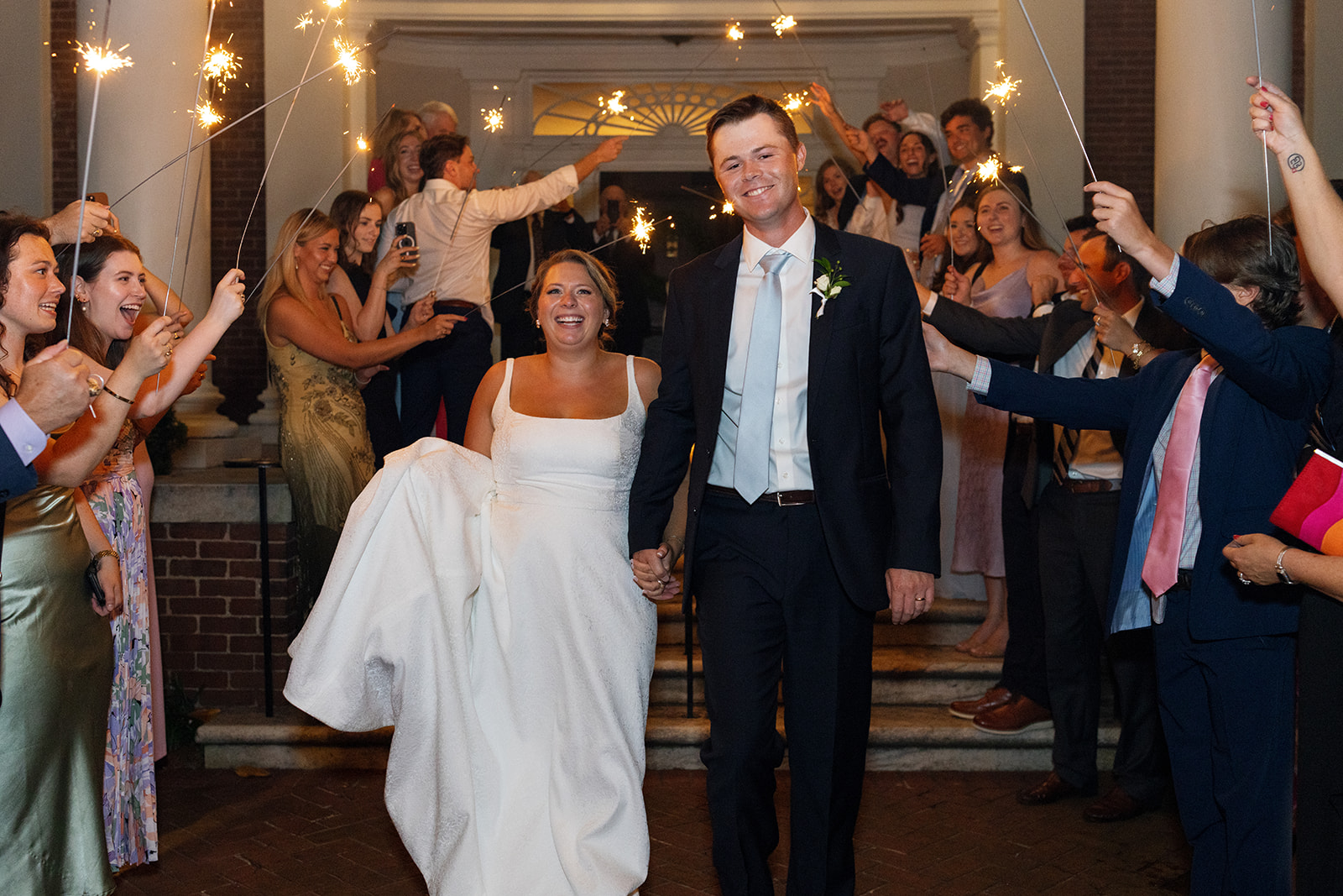 the couple walking through a sparkler exit 