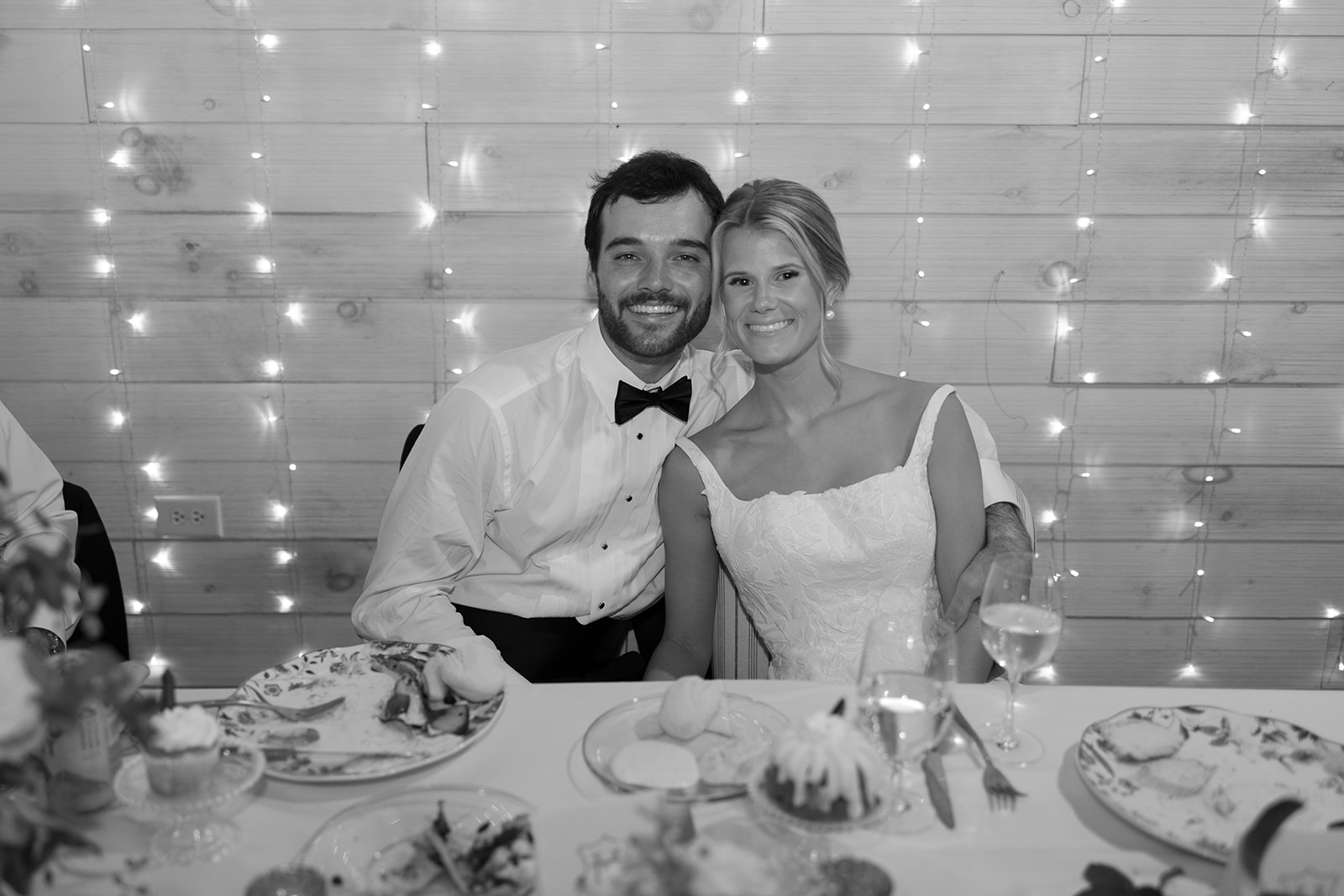 the bride and groom smiling at the head table