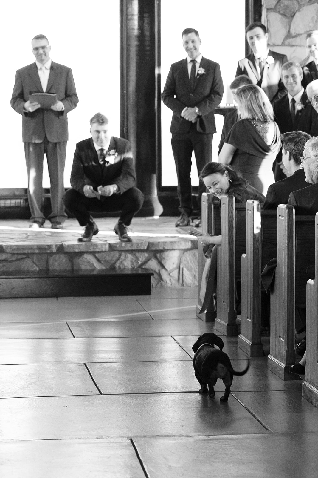 A small dog walks down the chapel aisle during the ceremony, delighting guests with a surprise appearance.