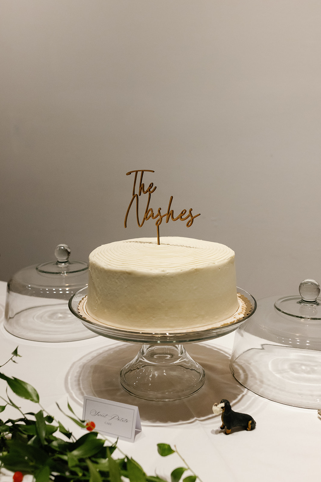 wedding cake on a table with a small dog figurine on the table