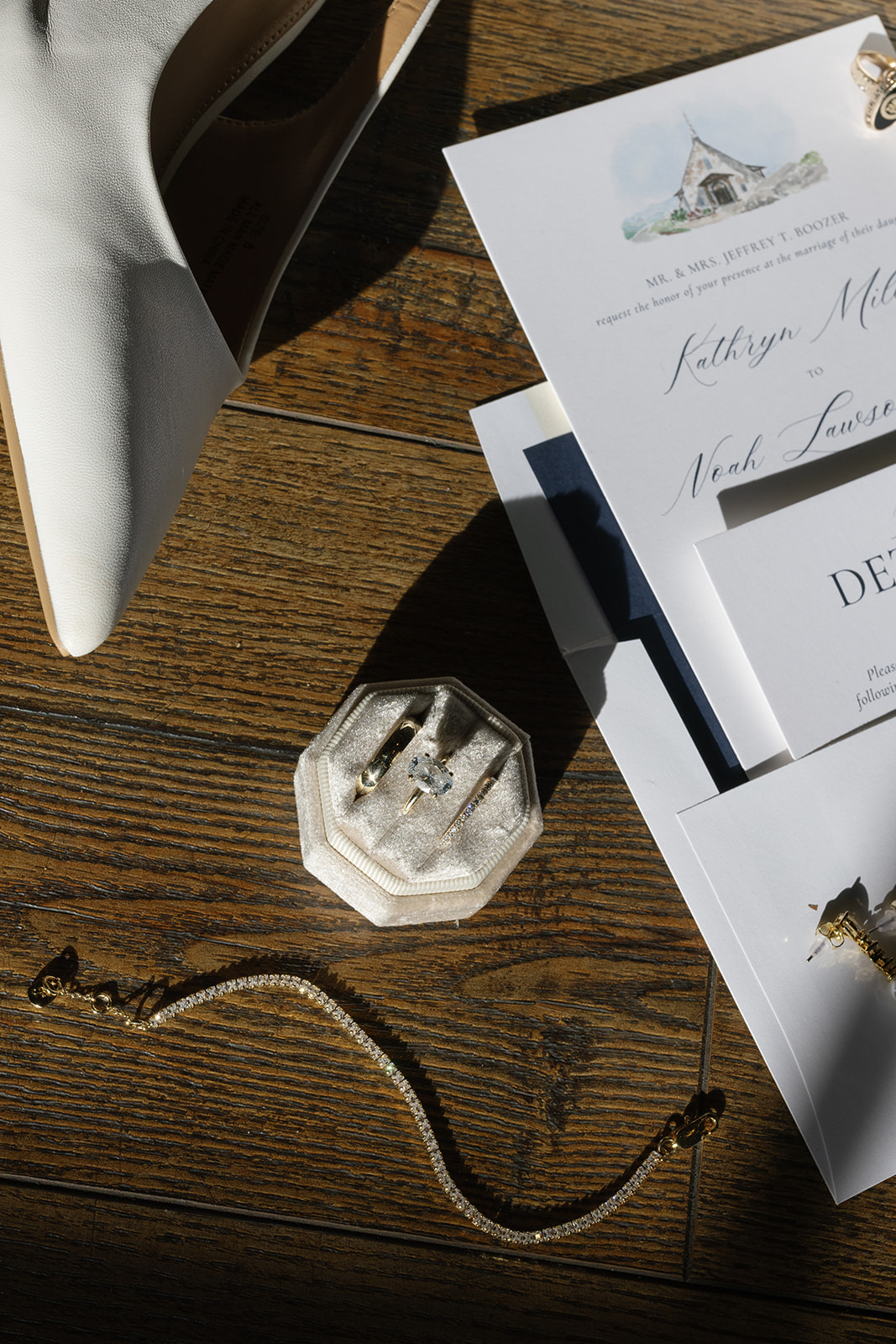 Timeless bridal jewelry and invitation suite laid out in soft light before the couple's South Carolina wedding.