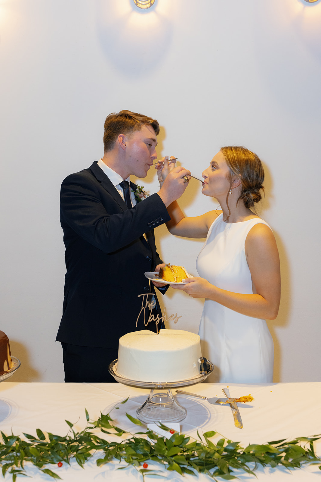 The bride and groom share a bite of  their wedding cake