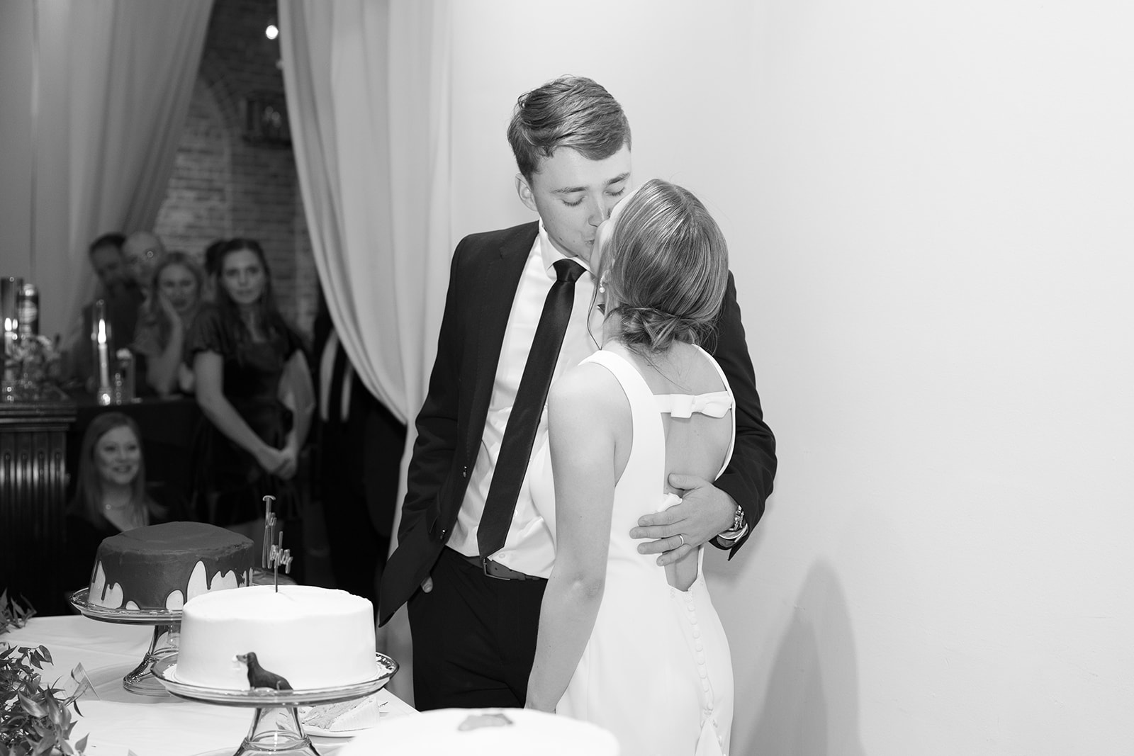 The bride and groom share a kiss before they cut the cake