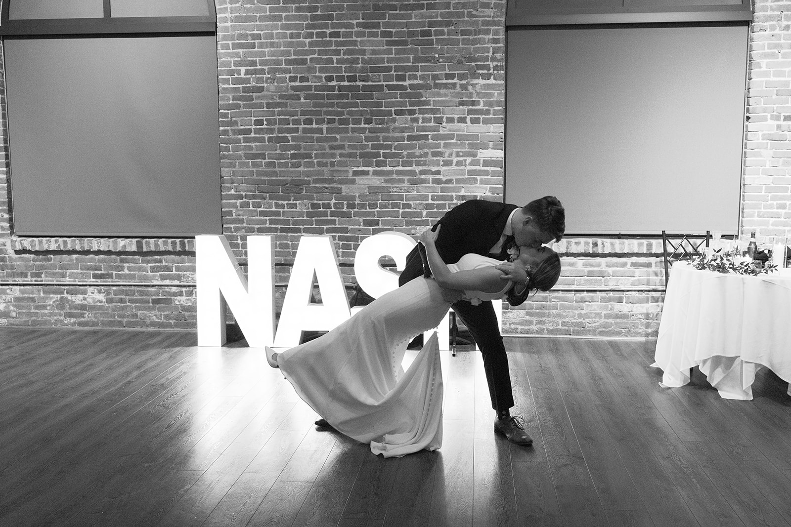 Bride and groom share a kiss as the groom dips her