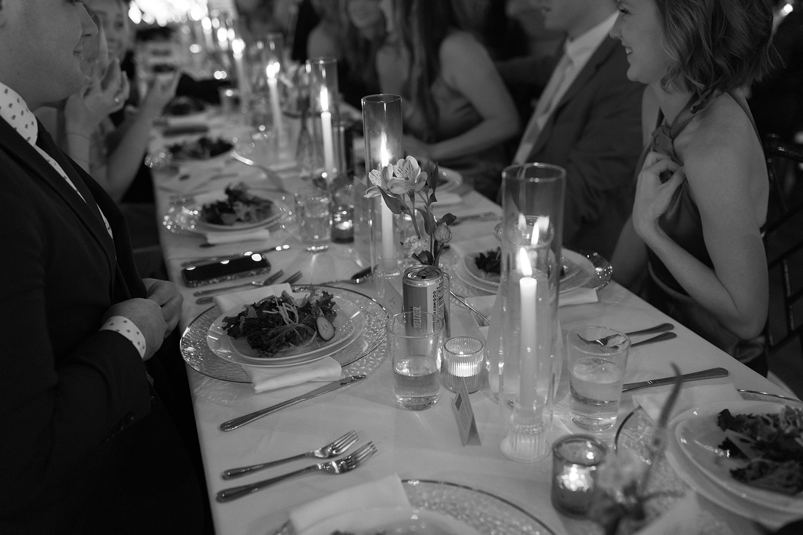 Guests smile and chat during the reception dinner, surrounded by candlelight.