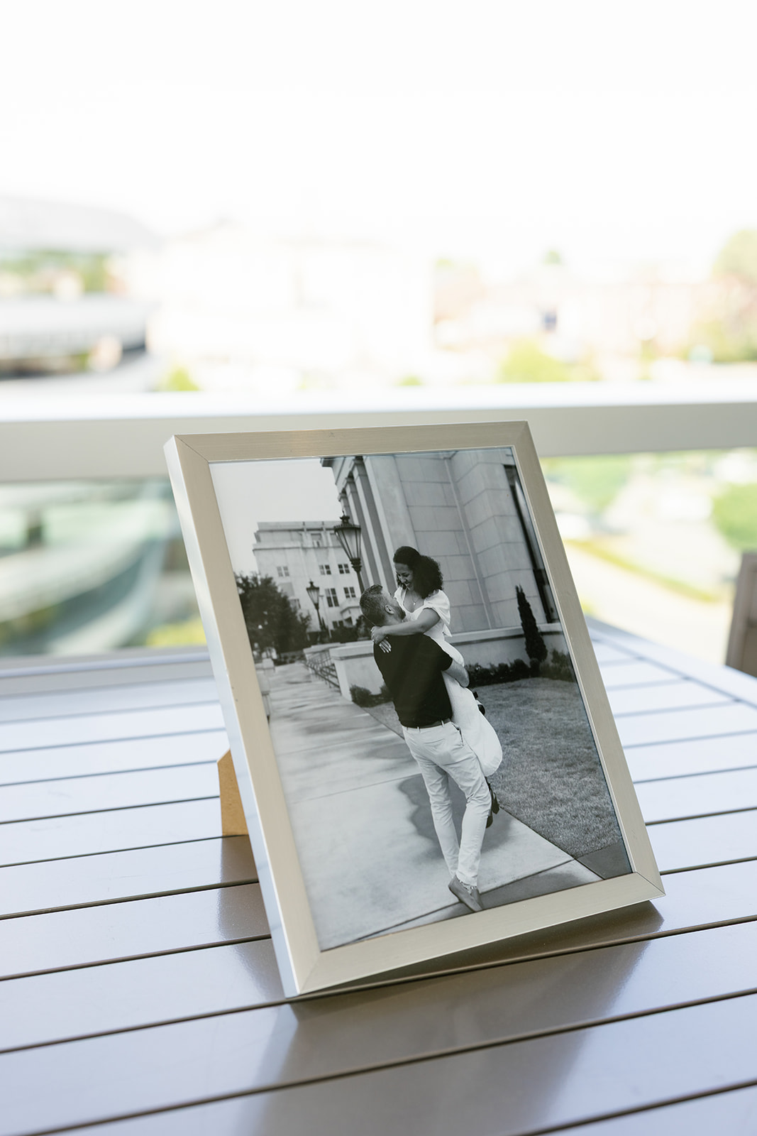 Framed black-and-white engagement photo of the couple near the historic clock in downtown Greenville.