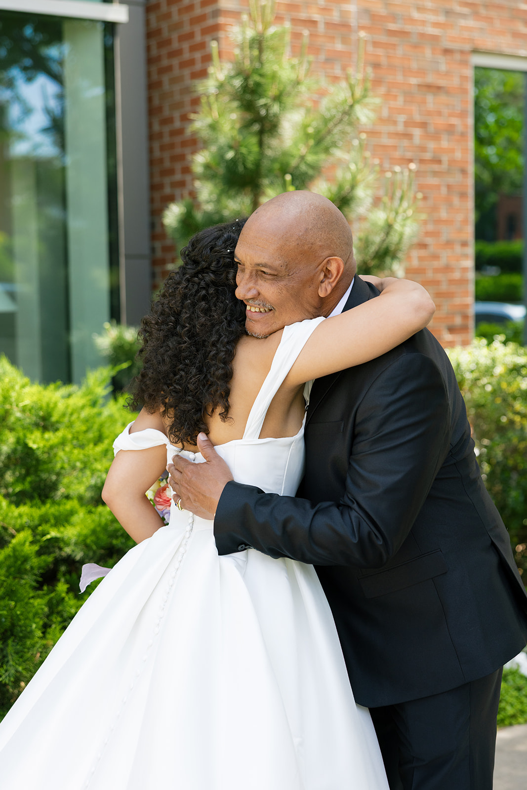 Bride and father share an emotional hug outside the venue before walking down the aisle.