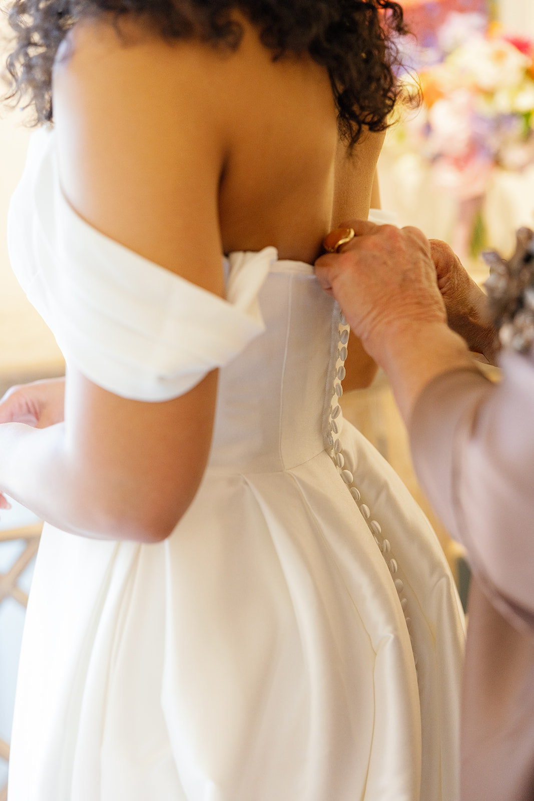 Bridal gown being buttoned up as the bride prepares for her wedding,  taken by a Greenville SC Wedding Photographer.