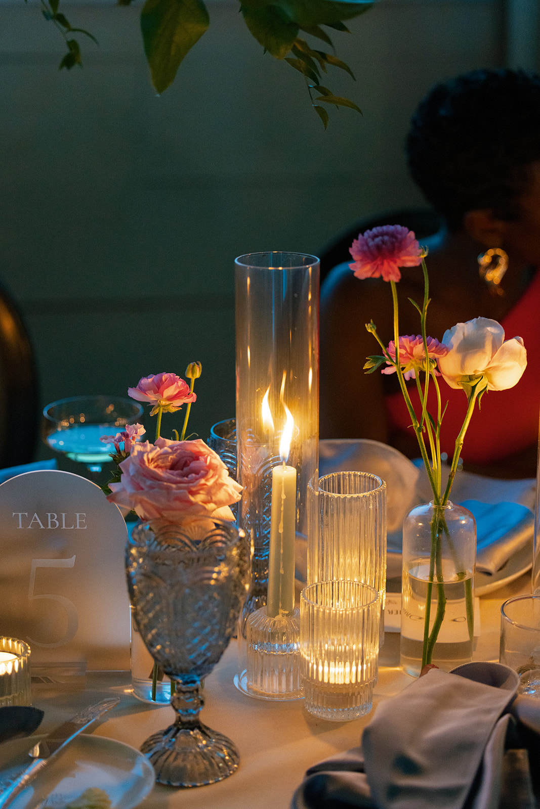 Candlelit reception table with pastel blooms and glass votives.