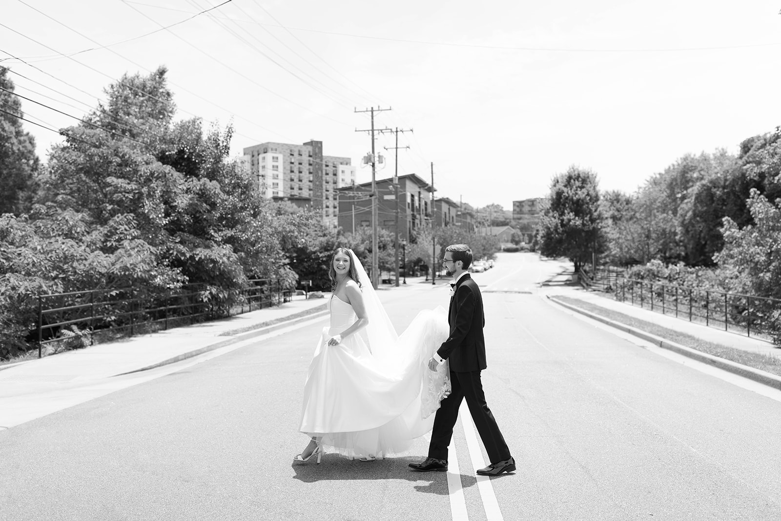 wedding couple walking on the street together back to their Greenville wedding venue