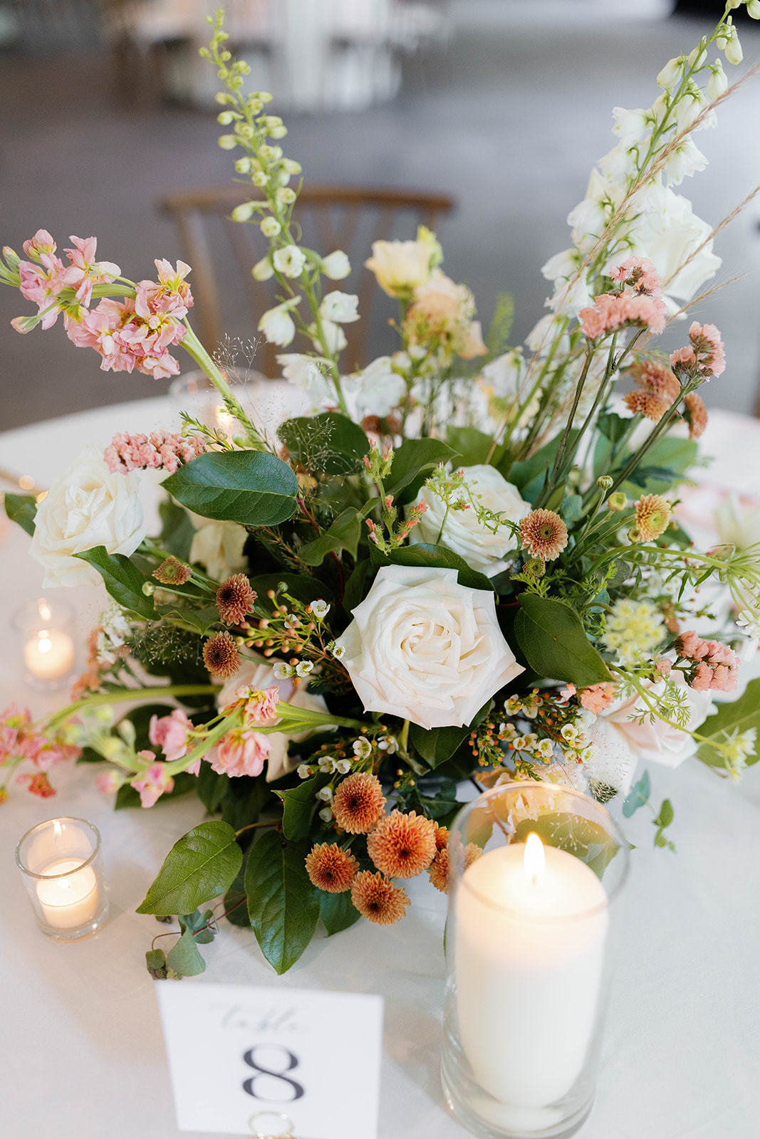 Soft blush and peach blooms decorate the reception tables at a romantic wedding at The 405.