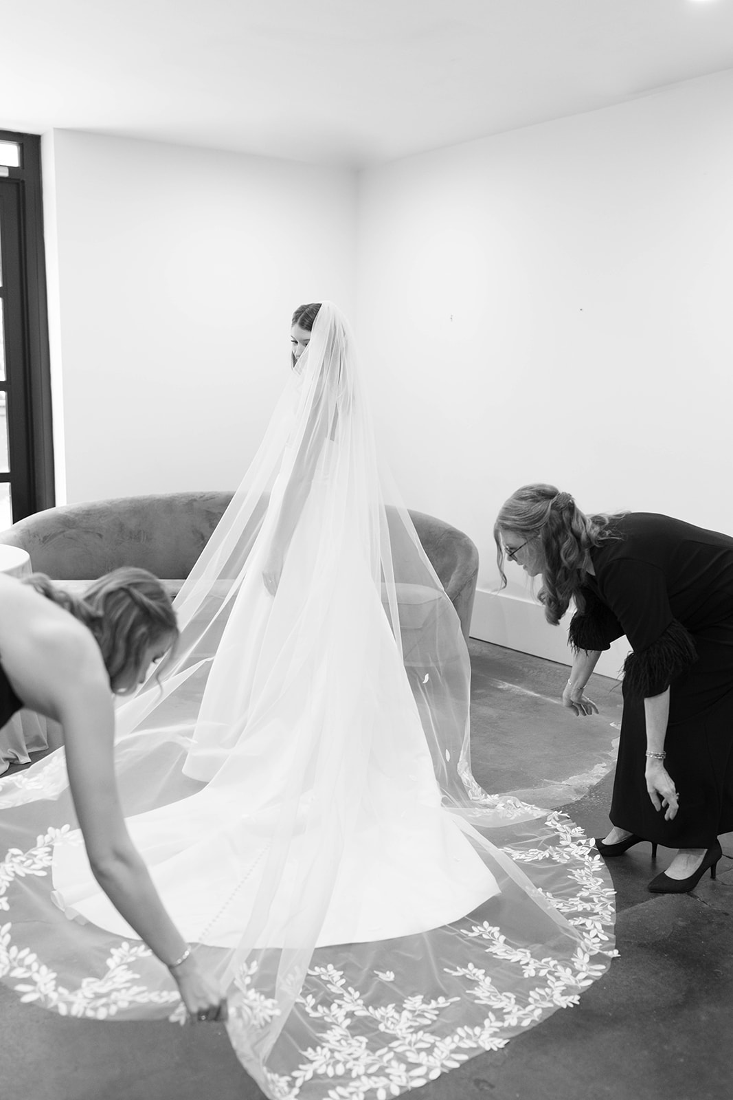The bride’s embroidered veil is fluffed by loved ones as she prepares for her ceremony at The 405, a timeless Greenville wedding venue.