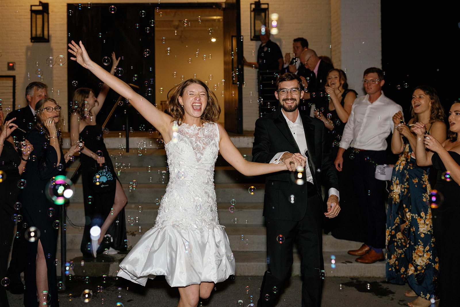 Bride beams with joy during a bubbly grand exit outside The 405 in downtown Greenville, South Carolina.