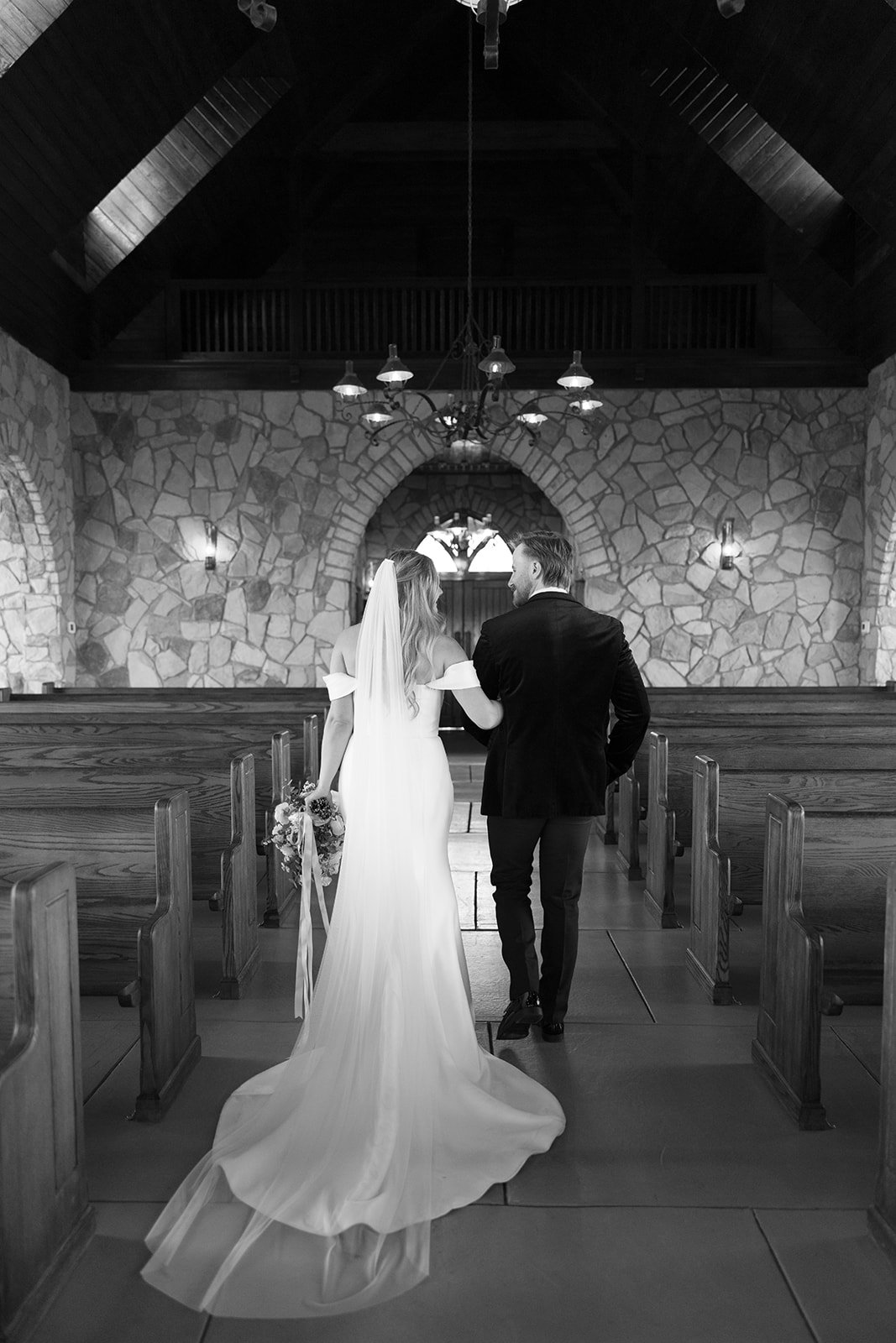 bride and groom in glassy chapel