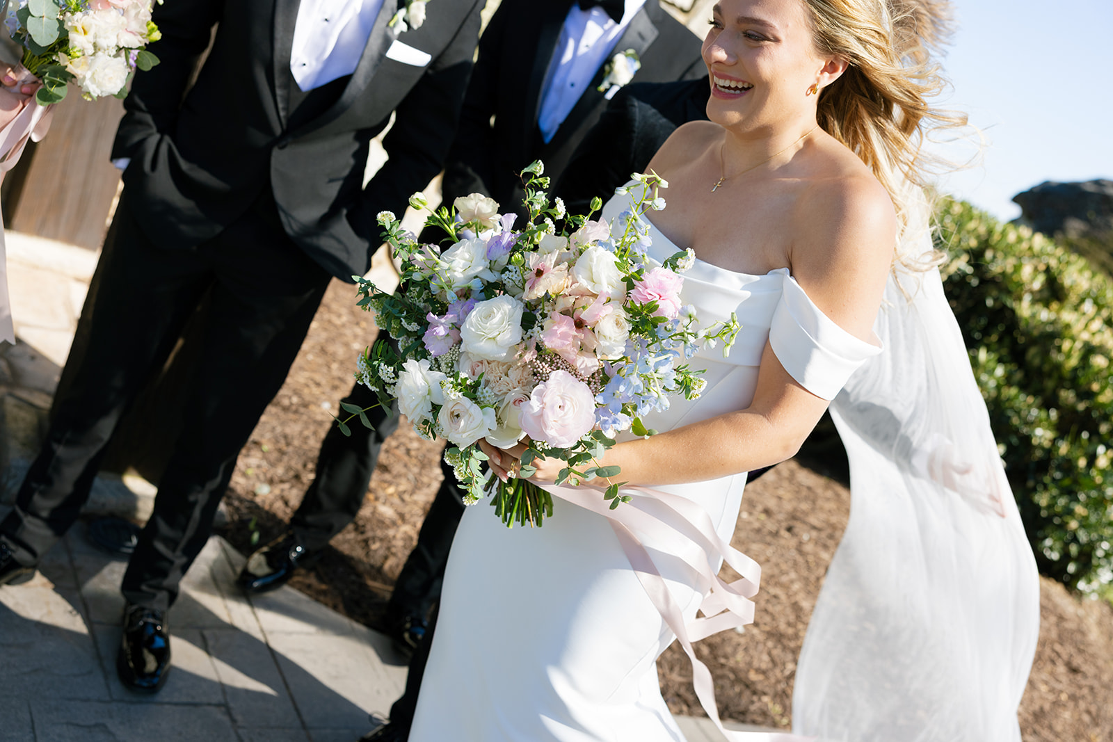 bride smiles with groom and wedding party