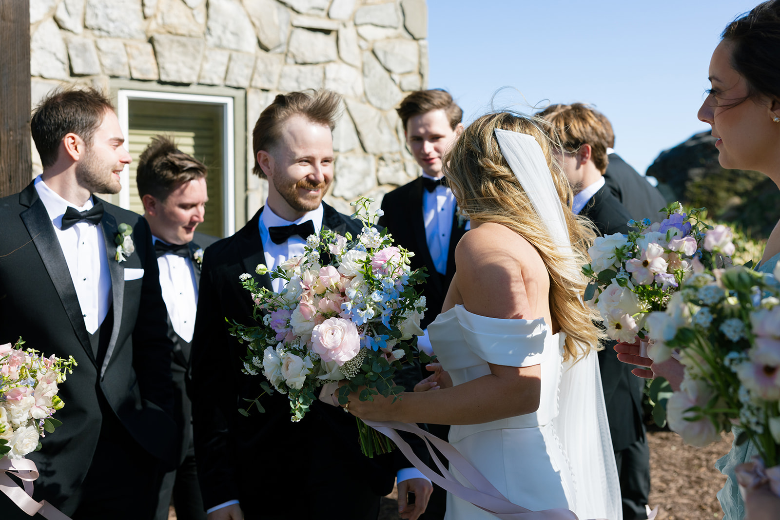 groom smiles at bride as hair blows in the wind