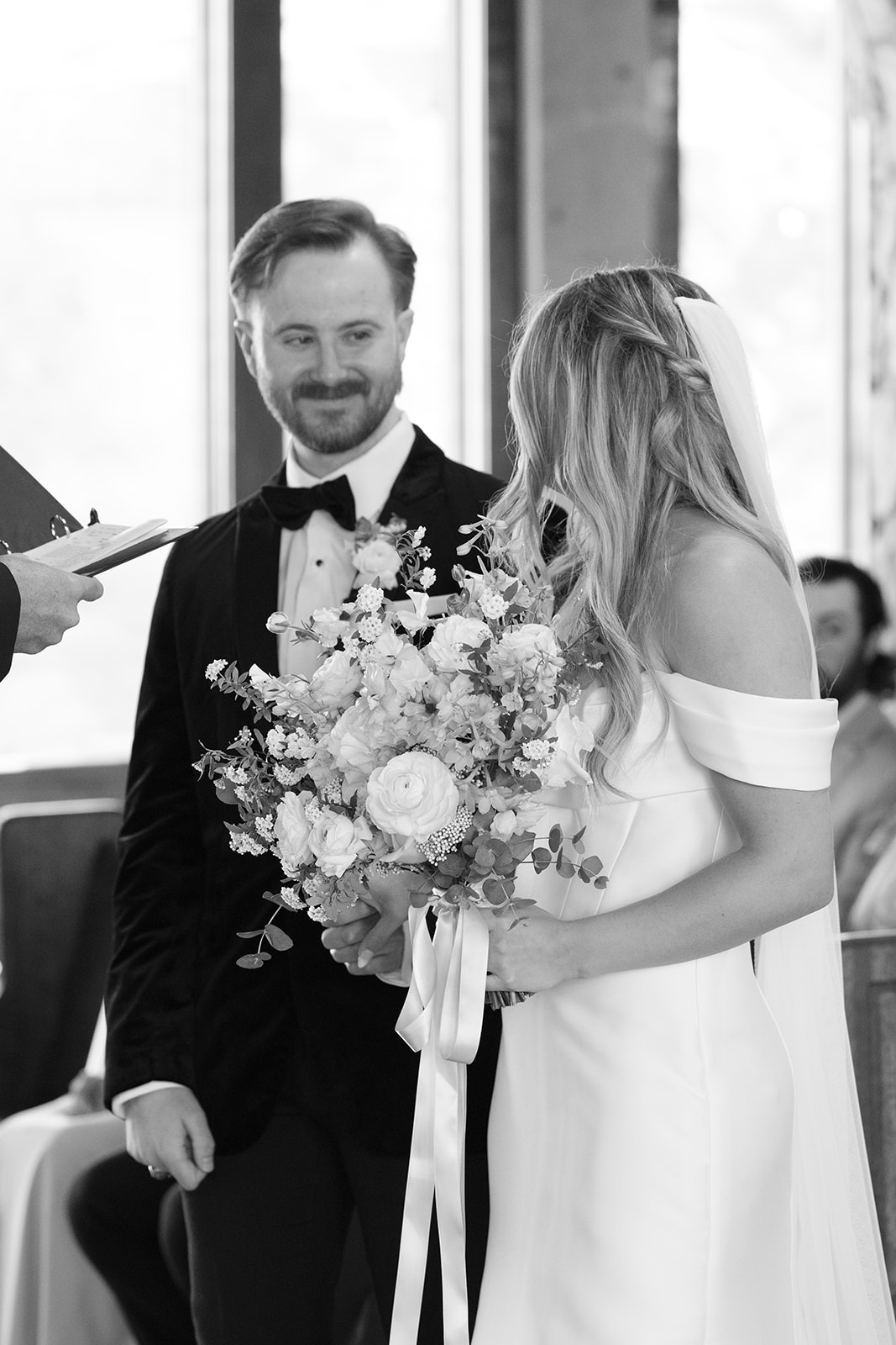 groom smiles lovingly at his bride during their wedding ceremony