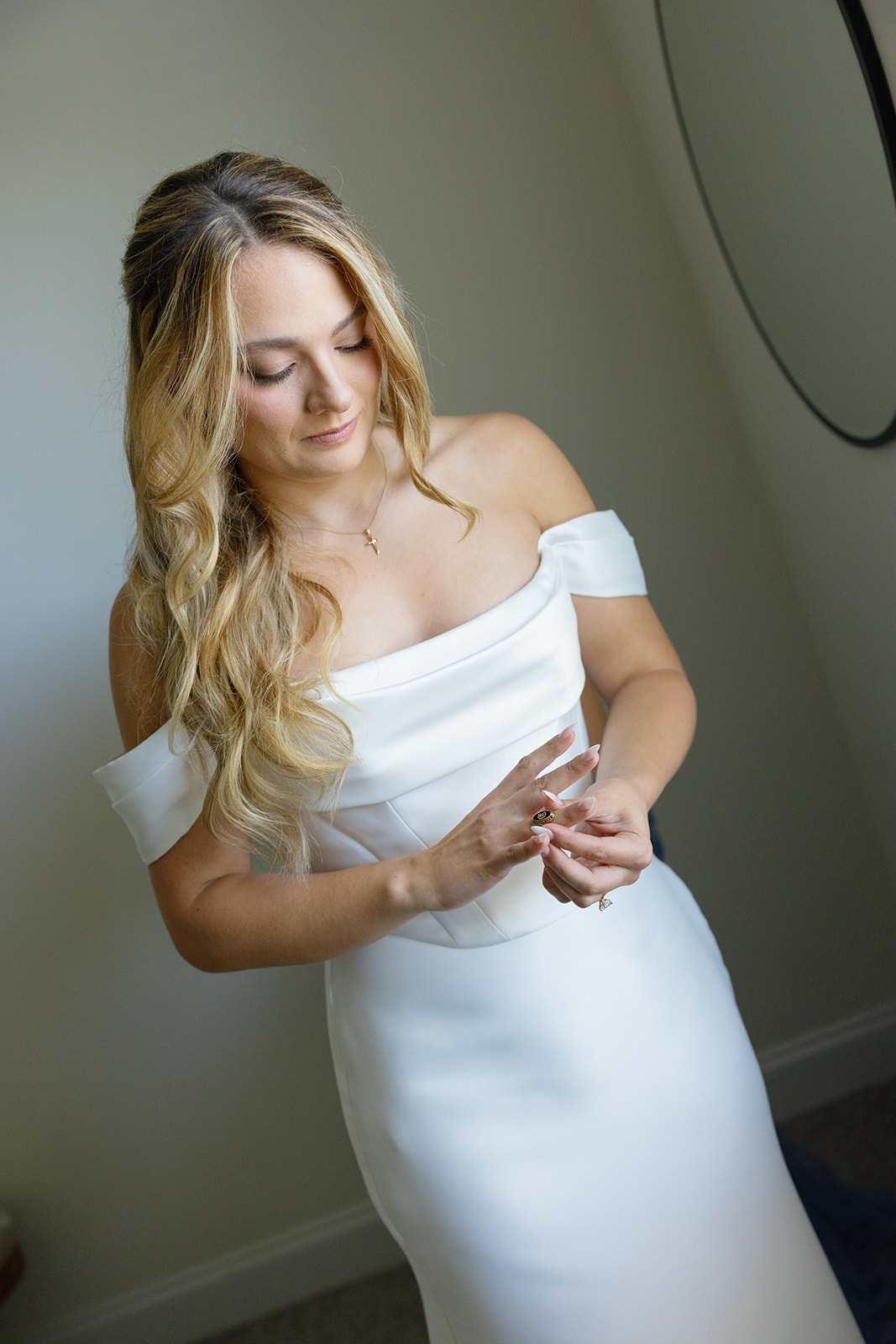 bride placing a ring on her finger as she gets ready for her wedding