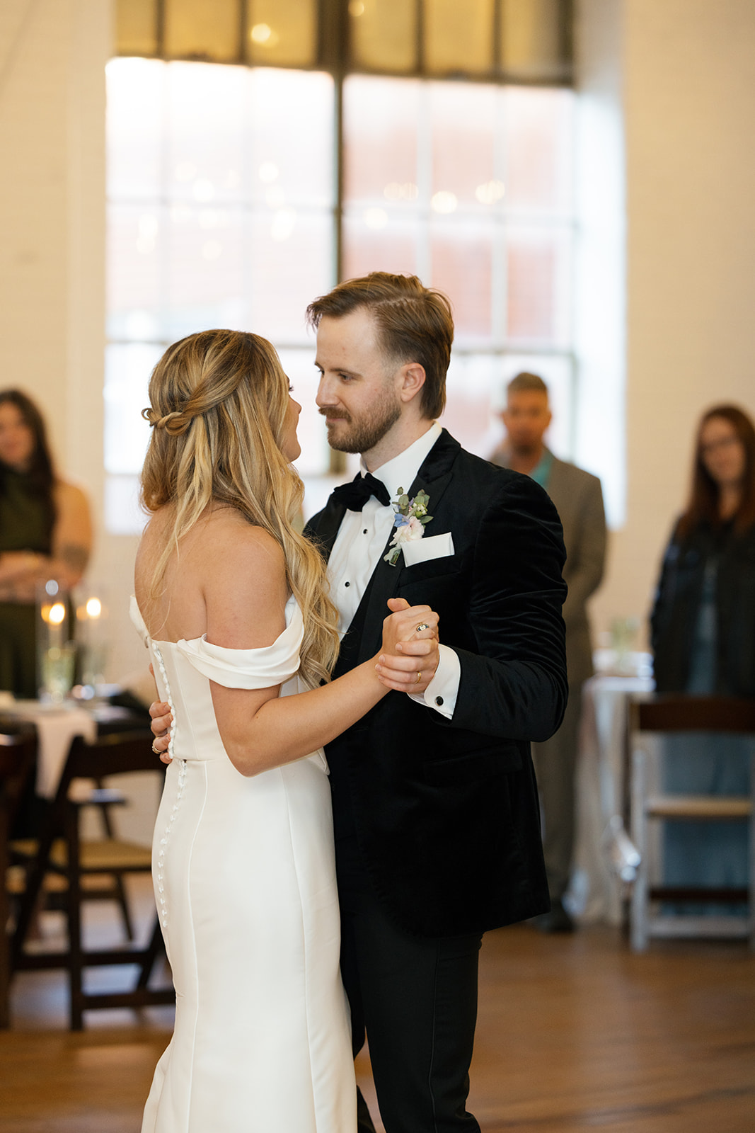 bride and groom looking into each other's eyes during first dance