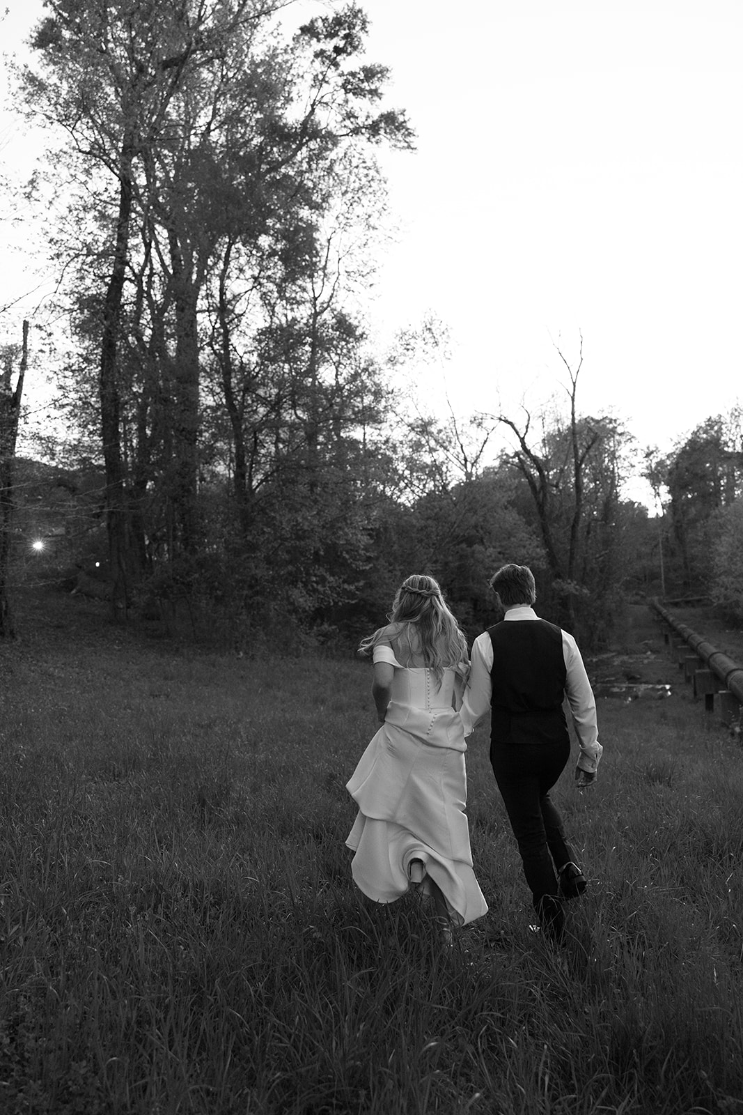 bridal couple walking through the grass