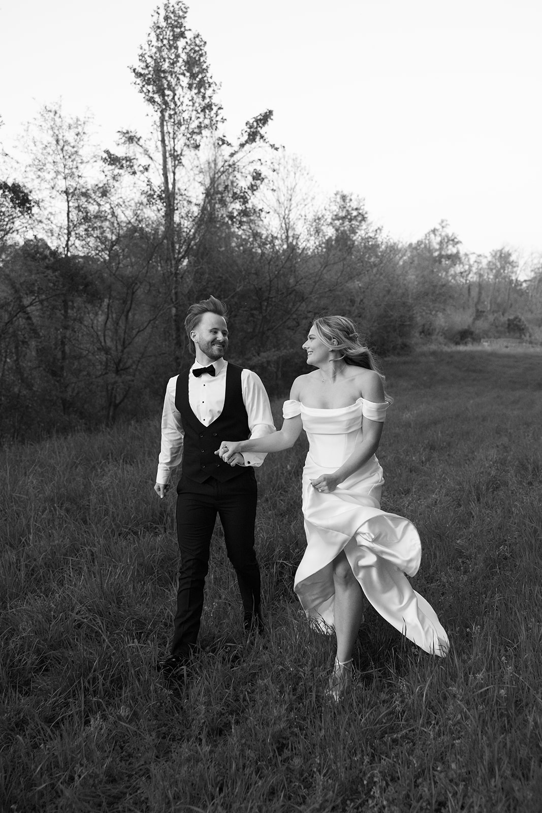 newly weds running through the grass together