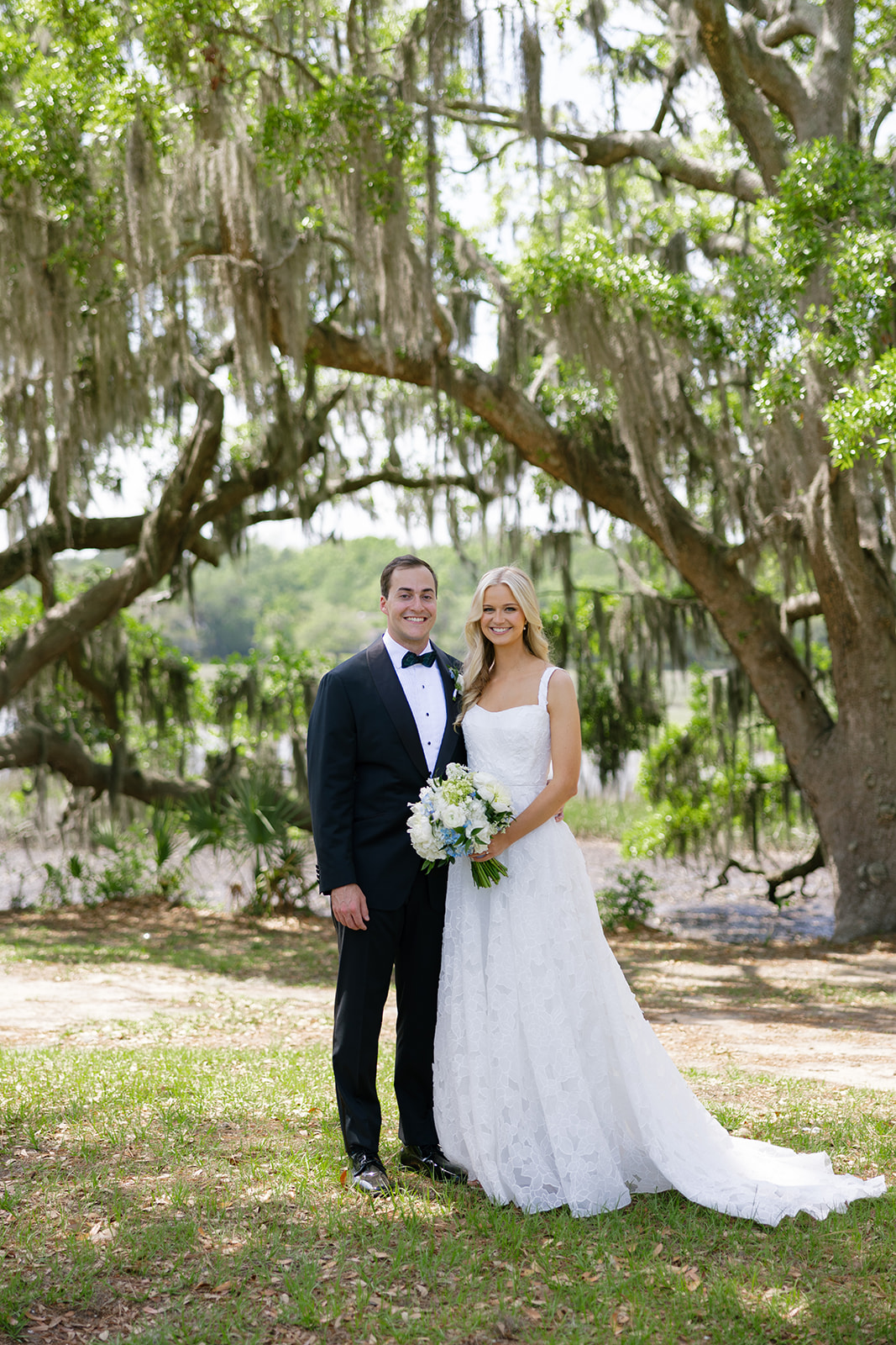 bride and groom under Avenue of Oaks
