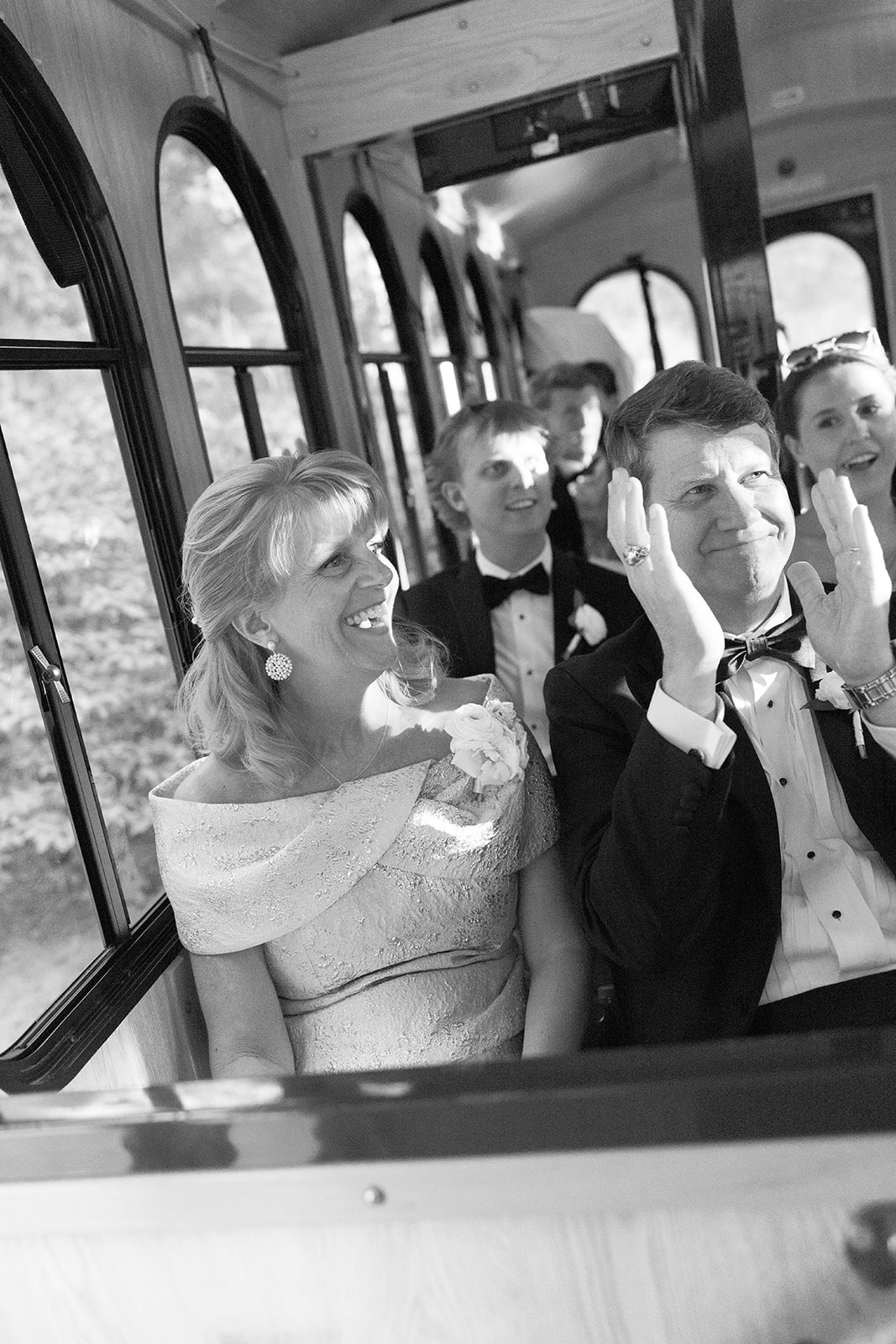 The bride's parents smile as they ride on the trolley to the wedding