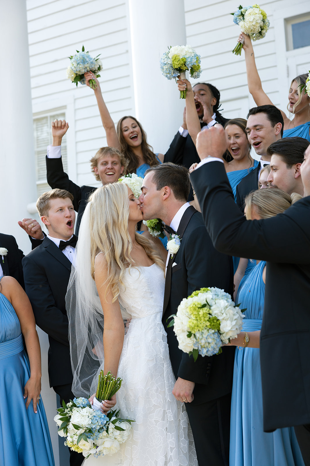 Bride and Groom share a kiss as their bridal party cheers at a Boone Hall Plantation wedding
