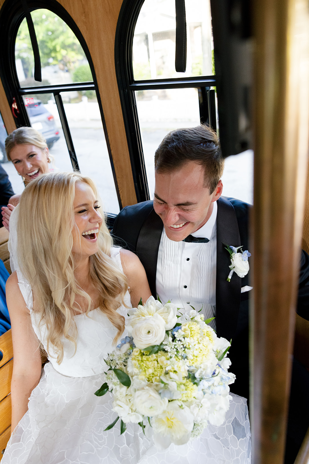 bride and groom laugh with their bridal party on the trolley ride to their wedding reception in Charleston