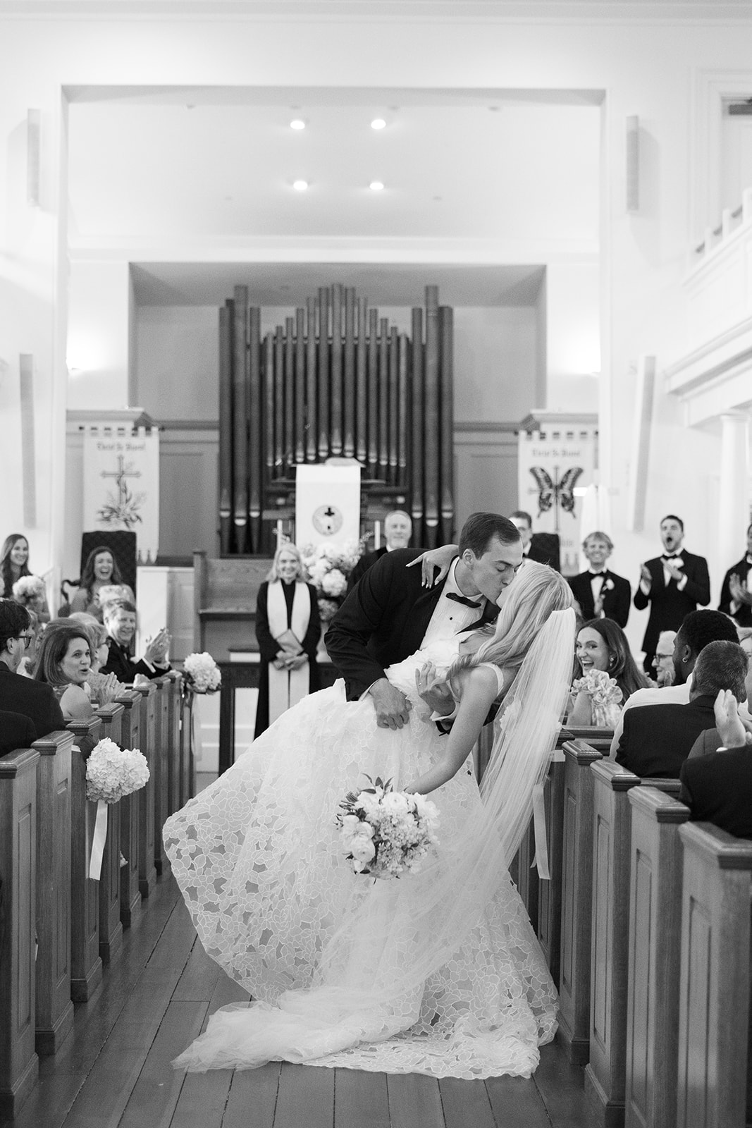 bride and groom share a kiss as they walk down the isle at Mount Pleasant Presbyterian