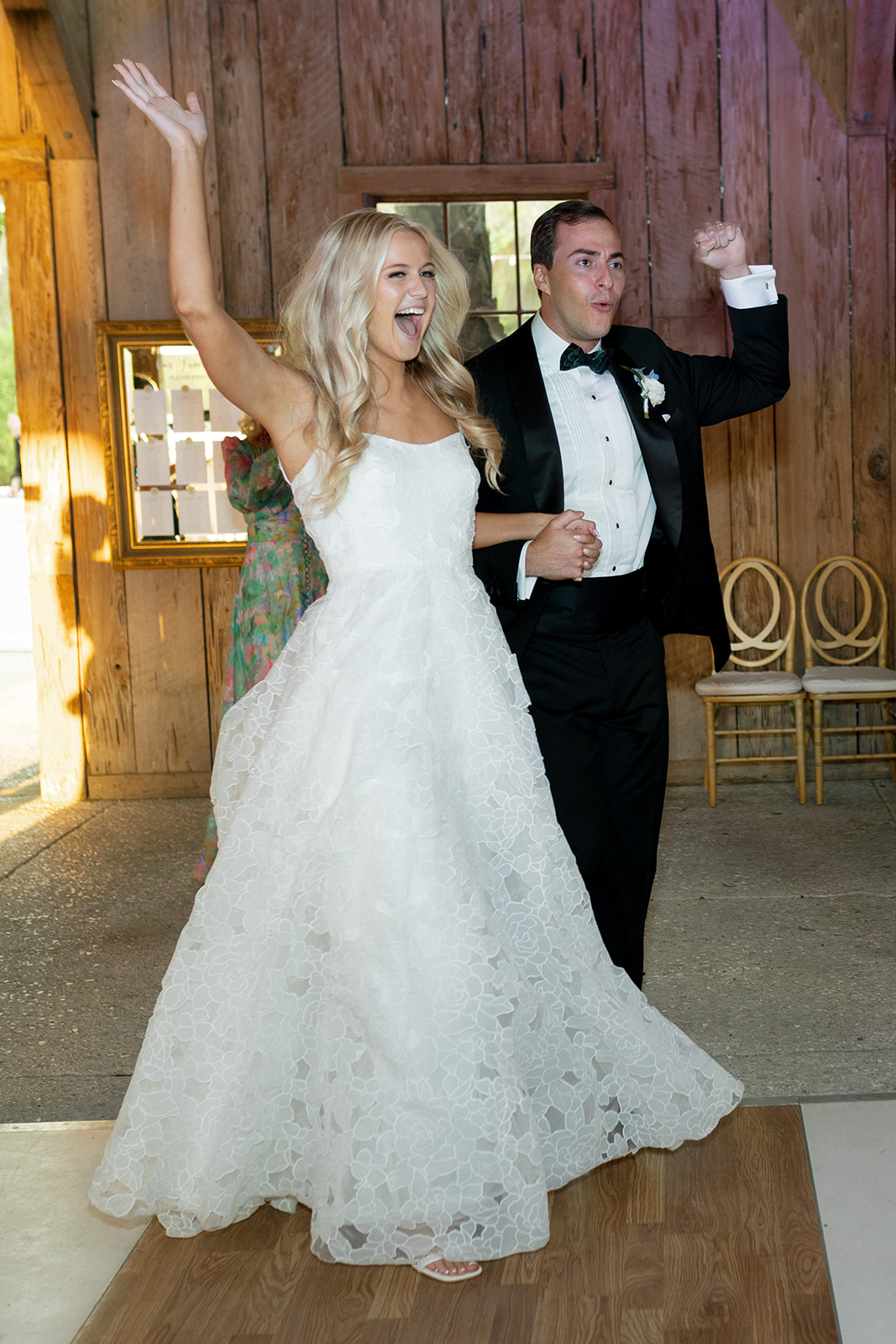 newlyweds joyfully enter their wedding reception