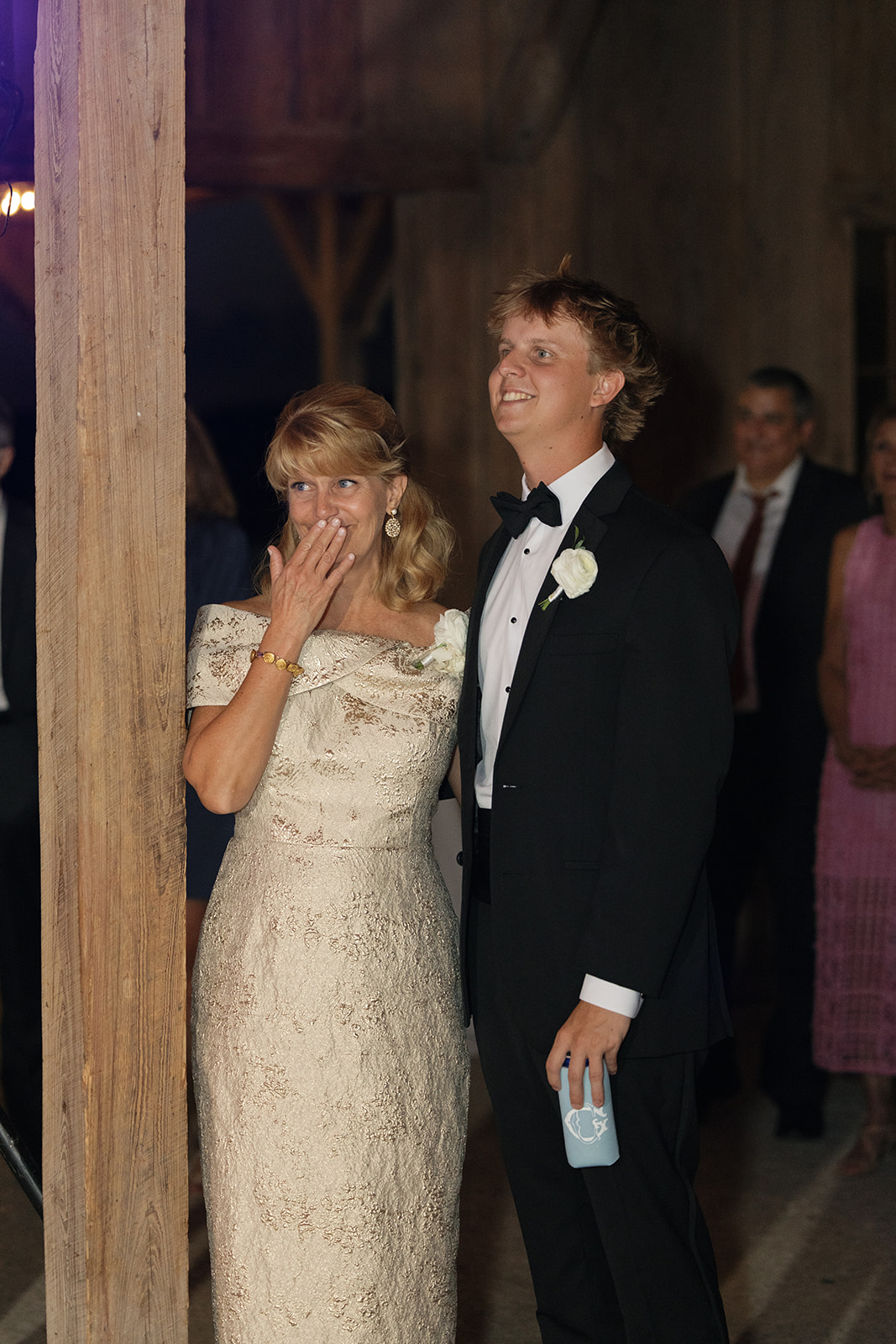 mother of the bride smiles as the newlyweds enter their wedding reception