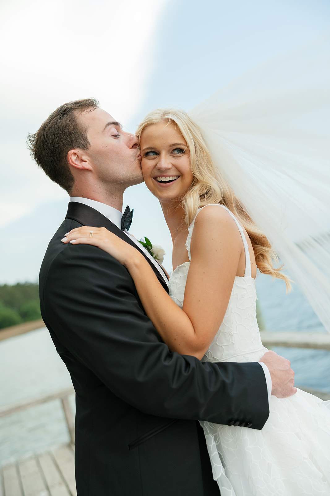 Groom kisses bride's forehead on the dock in Charleston
