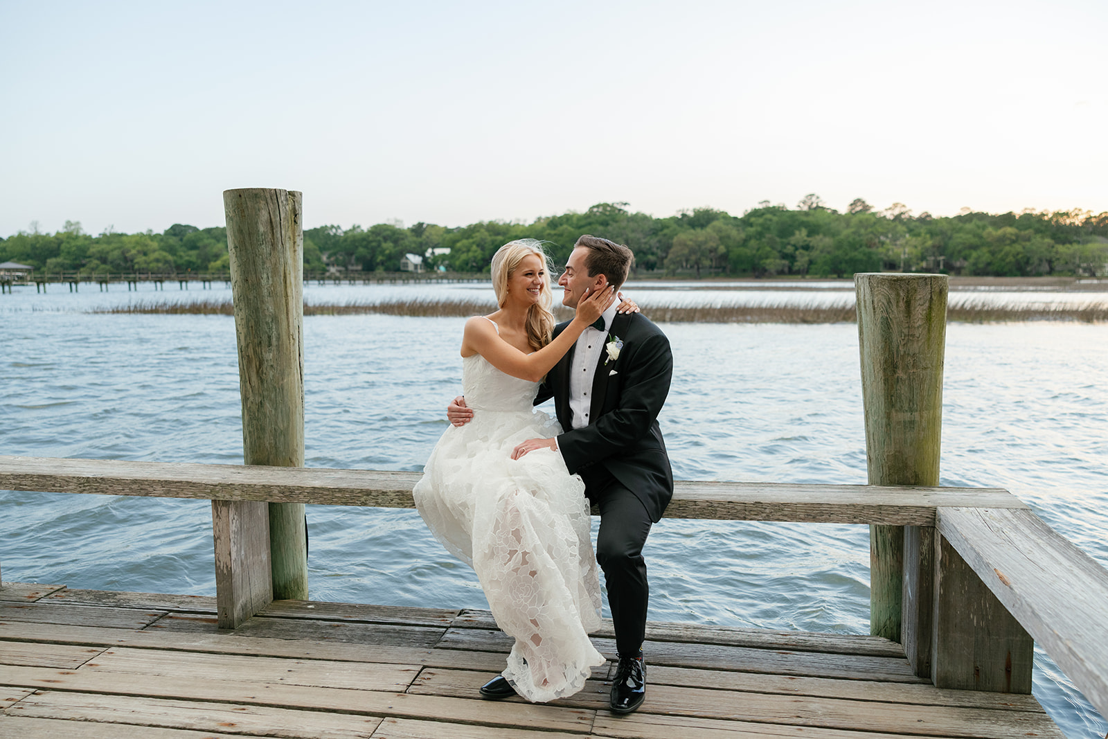 Bride and groom embrace on the dock at Boone Hall Plantation