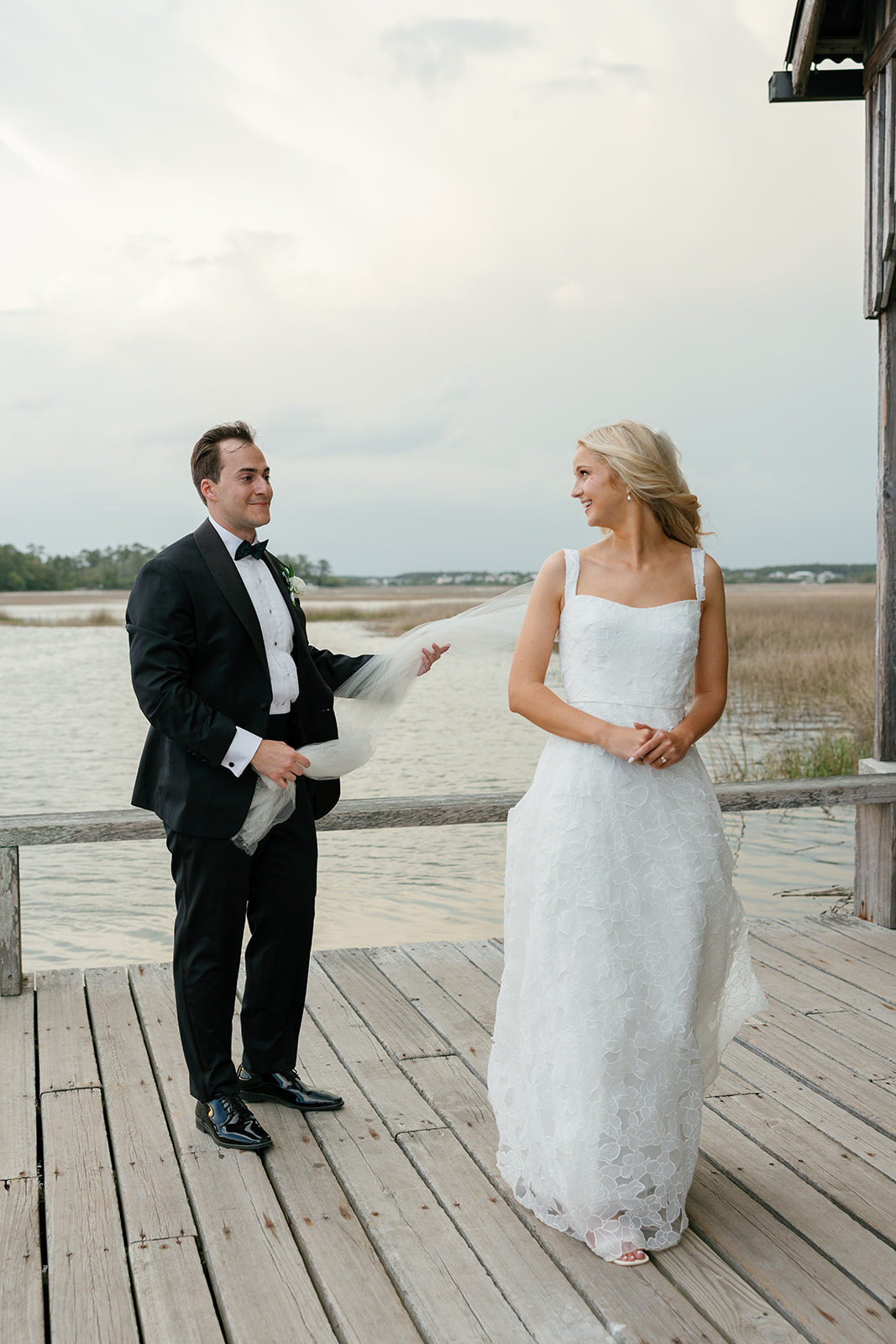 bride lovingly looks back at the groom on the dock at a Charleston wedding venue