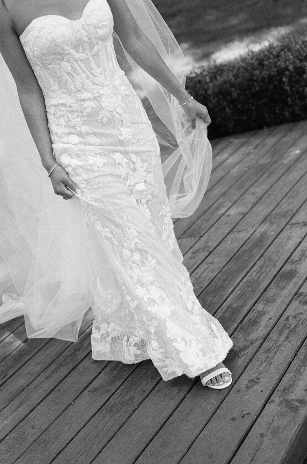 film photo of bride's wedding dress details as she walks outside The Venue at Edgewood