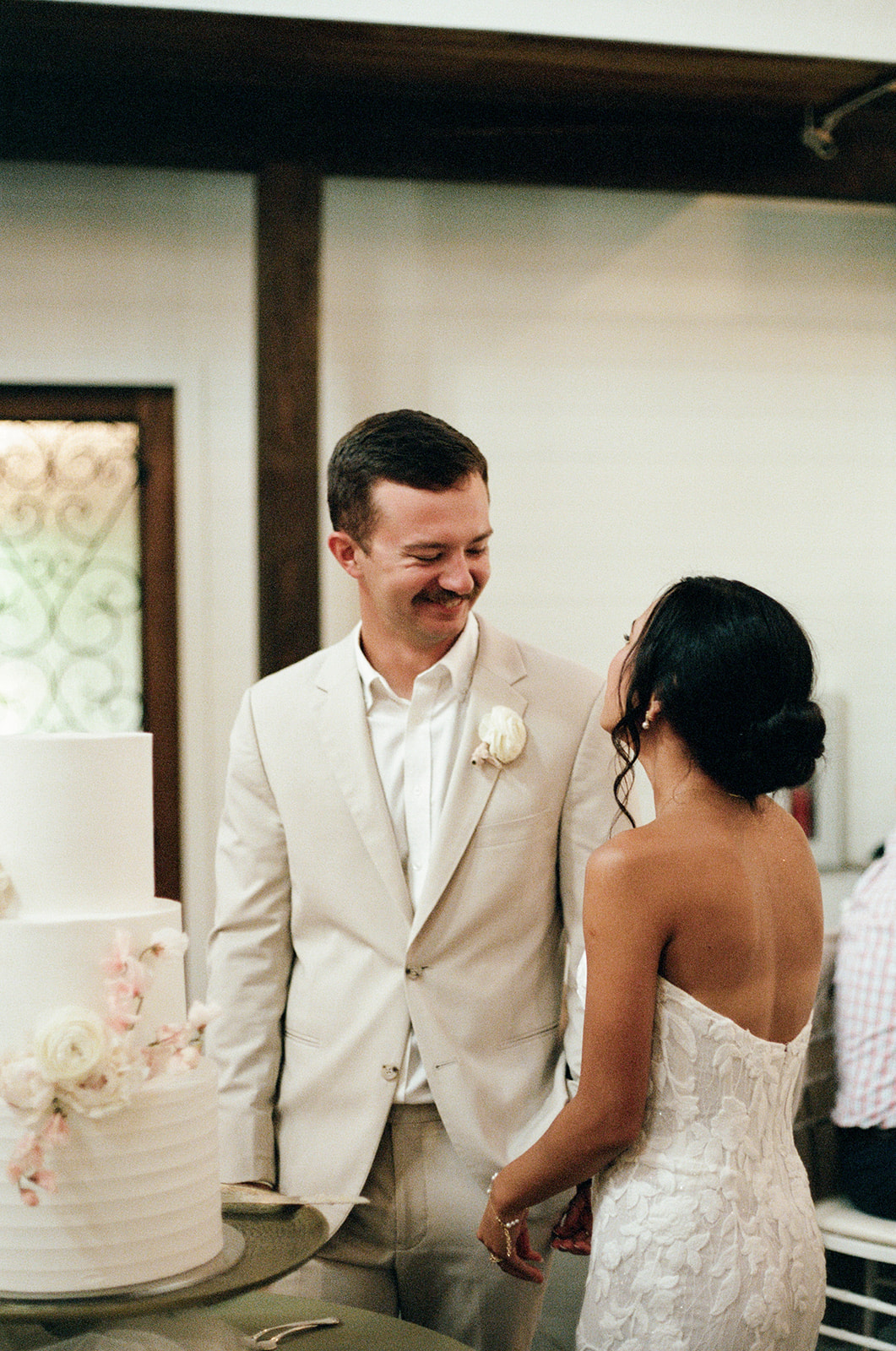 Film photo of bride and groom sharing a sweet moment before cutting their wedding cake