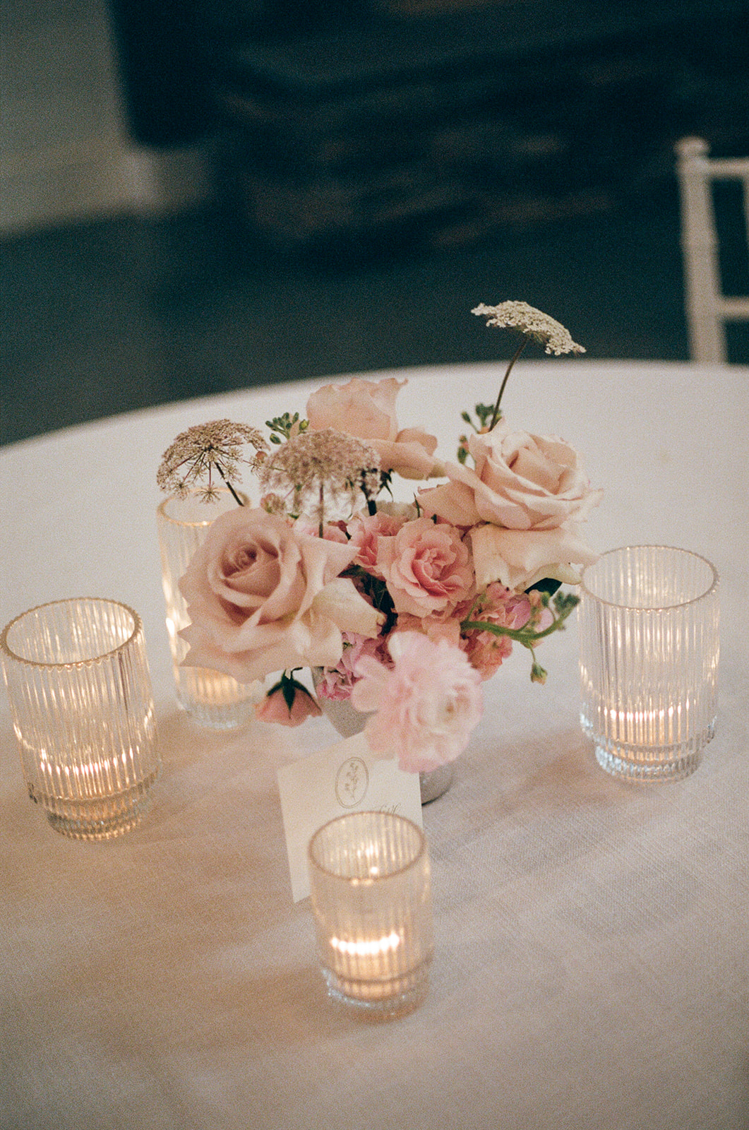 film photo of pastel florals and candlelit table at a South Carolina wedding reception 