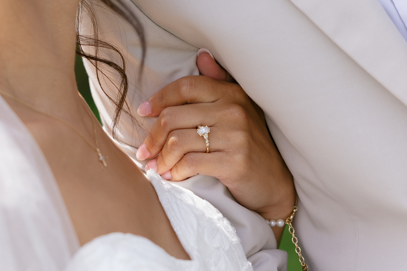 close-up shot of the bride's wedding ring as she holds her husbands arm