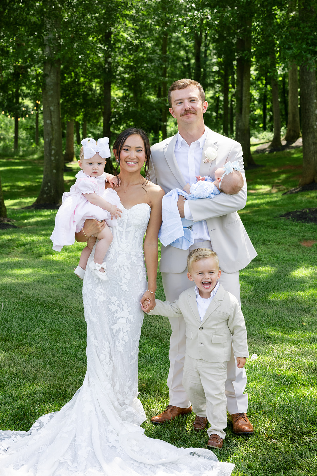 Bride and groom pose with their flower girl and ring bearer 